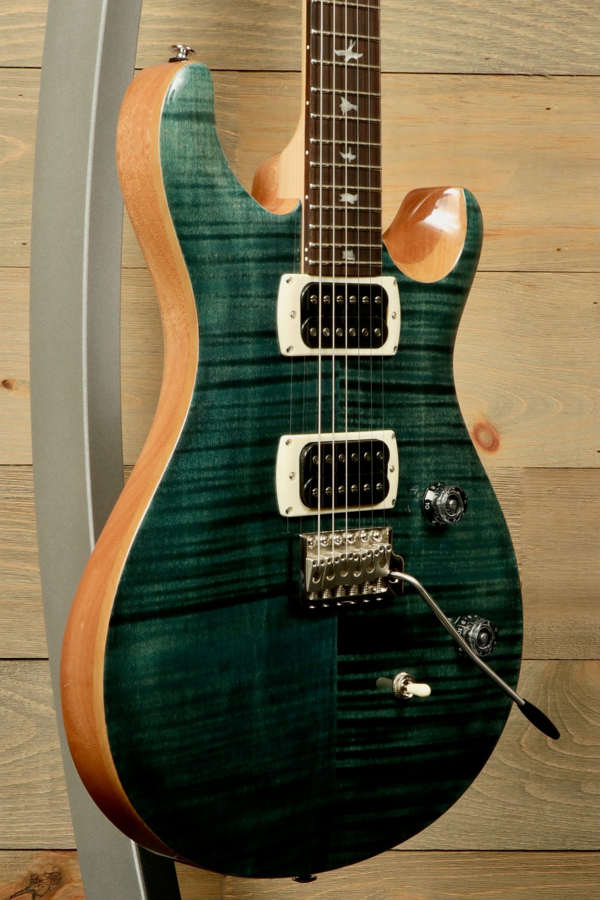 PRS electric guitar with a teal finish and dual pickups, front view showcasing its stunning design