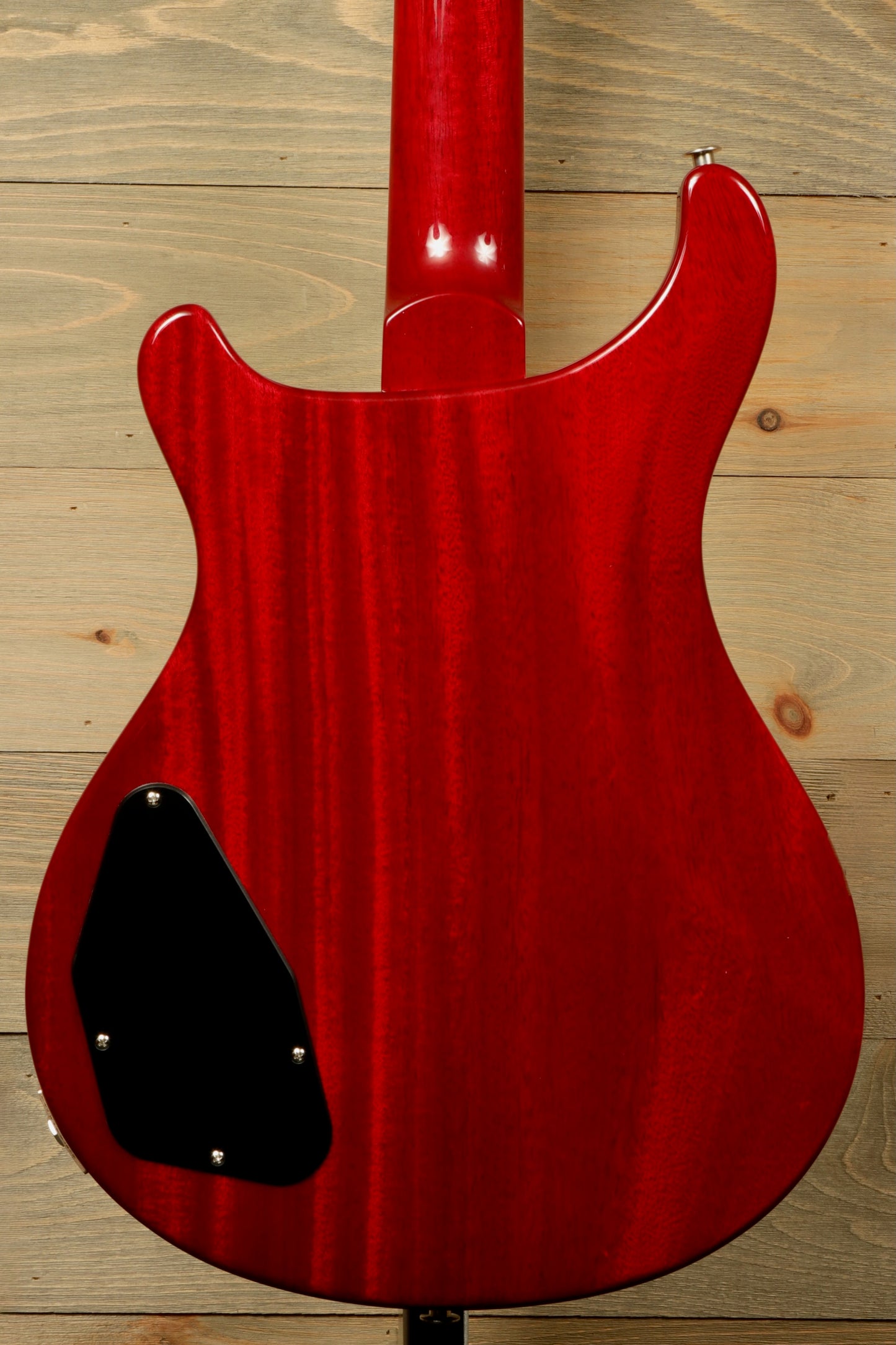 Close-up of PRS 594 McCarty electric guitar body in a striking red finish with a smooth texture