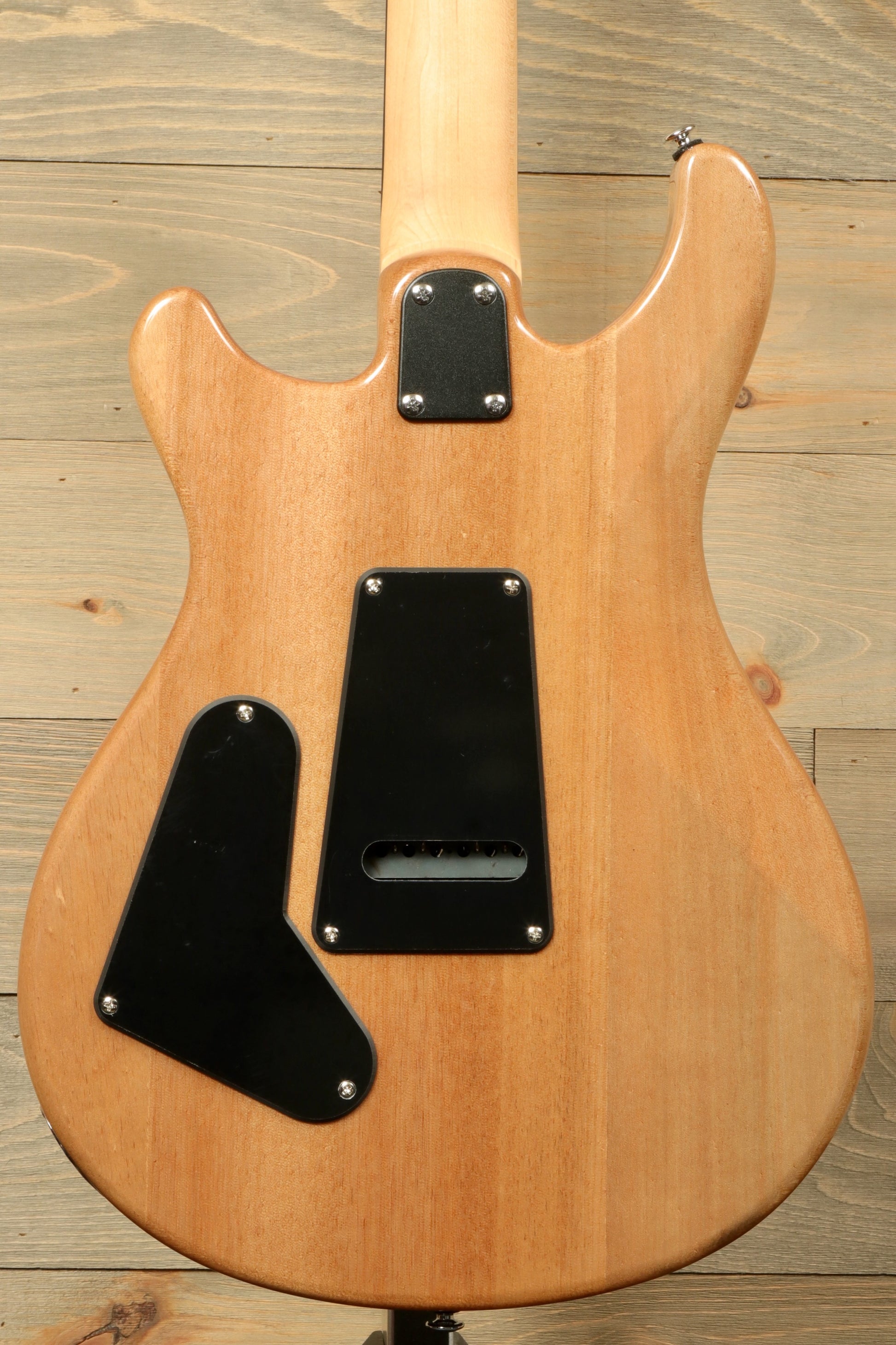 Back view of PRS SE CE24 electric guitar showcasing its smooth wood finish and control cavity