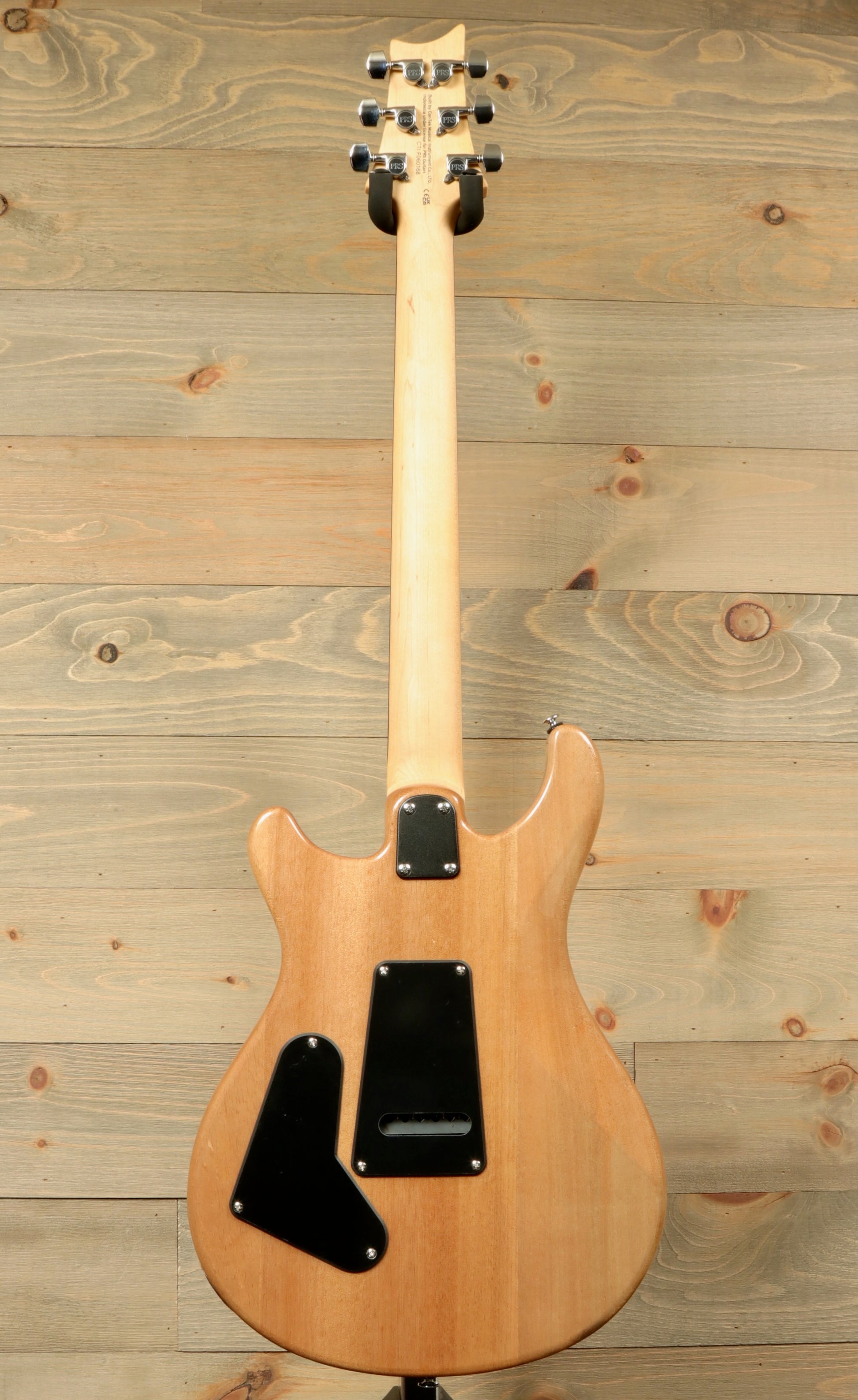 Back view of PRS SE CE24 electric guitar with a natural wood finish and sleek design