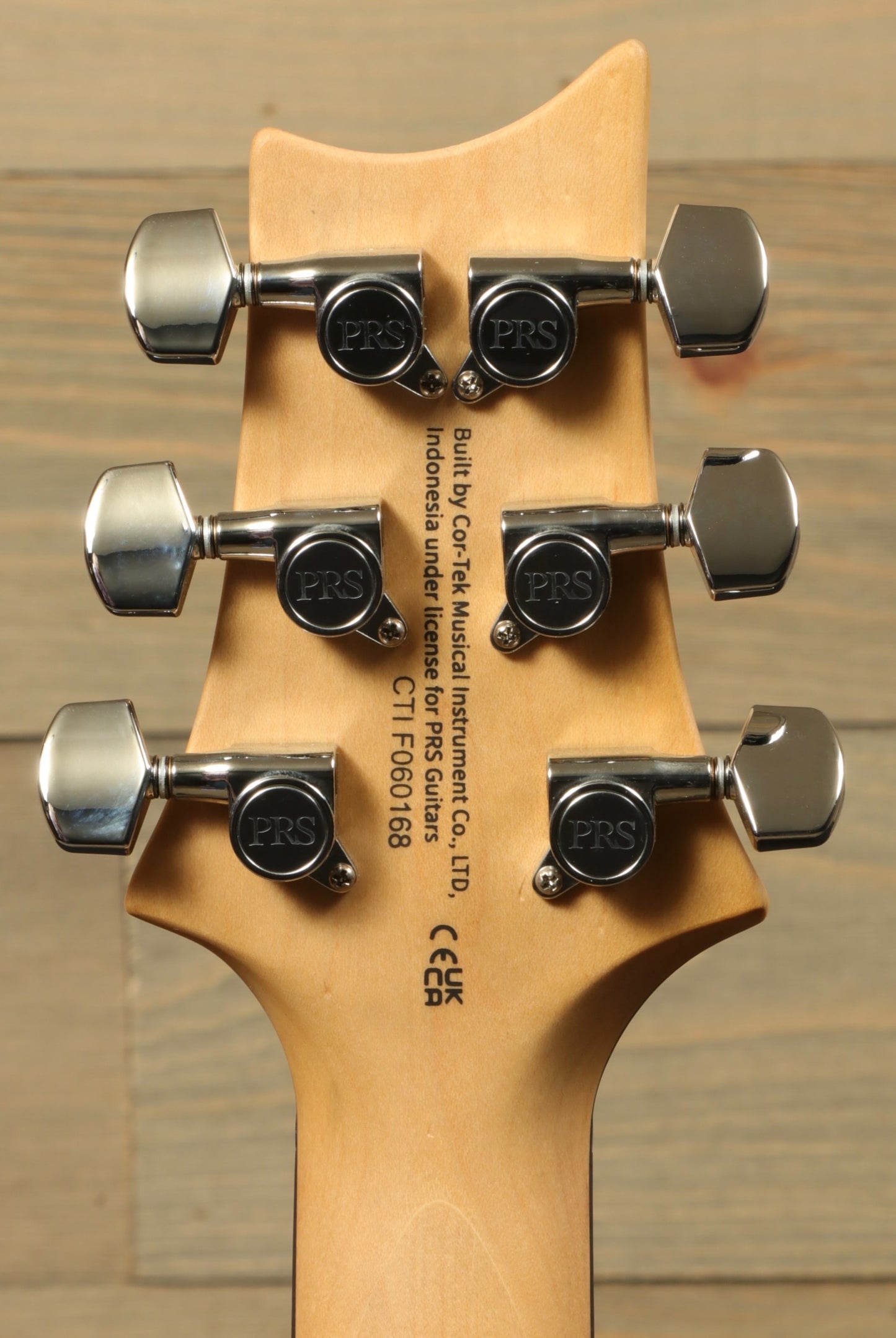Back view of PRS SE CE24 electric guitar showing tuning pegs and craftsmanship details