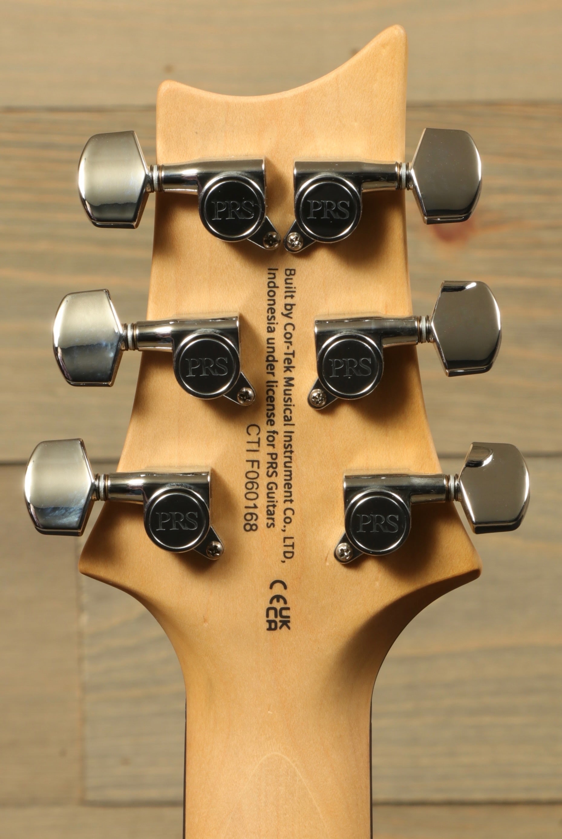 Back view of PRS SE CE24 electric guitar showing tuning pegs and craftsmanship details