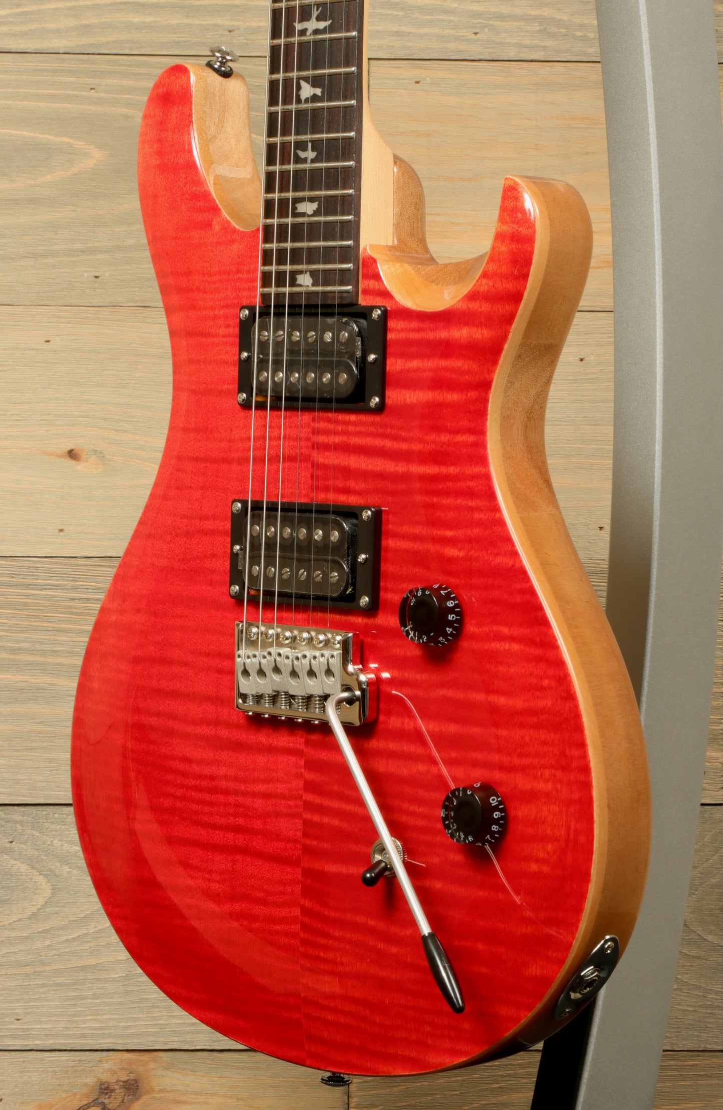 PRS SE CE24 electric guitar in vibrant red with unique body shape and dual humbucker pickups