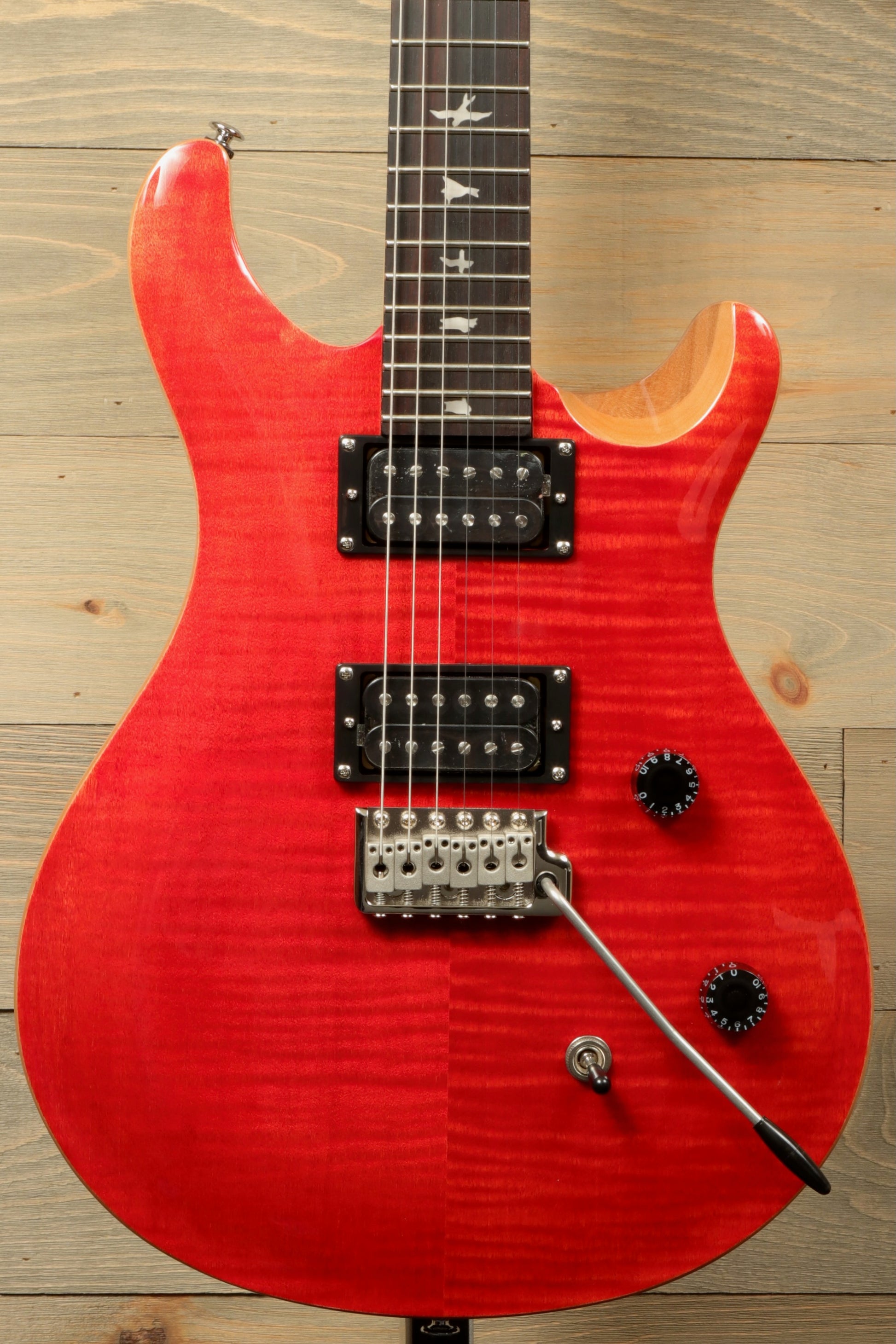 PRS SE CE24 electric guitar in vibrant red finish with distinctive tone controls and attractive design