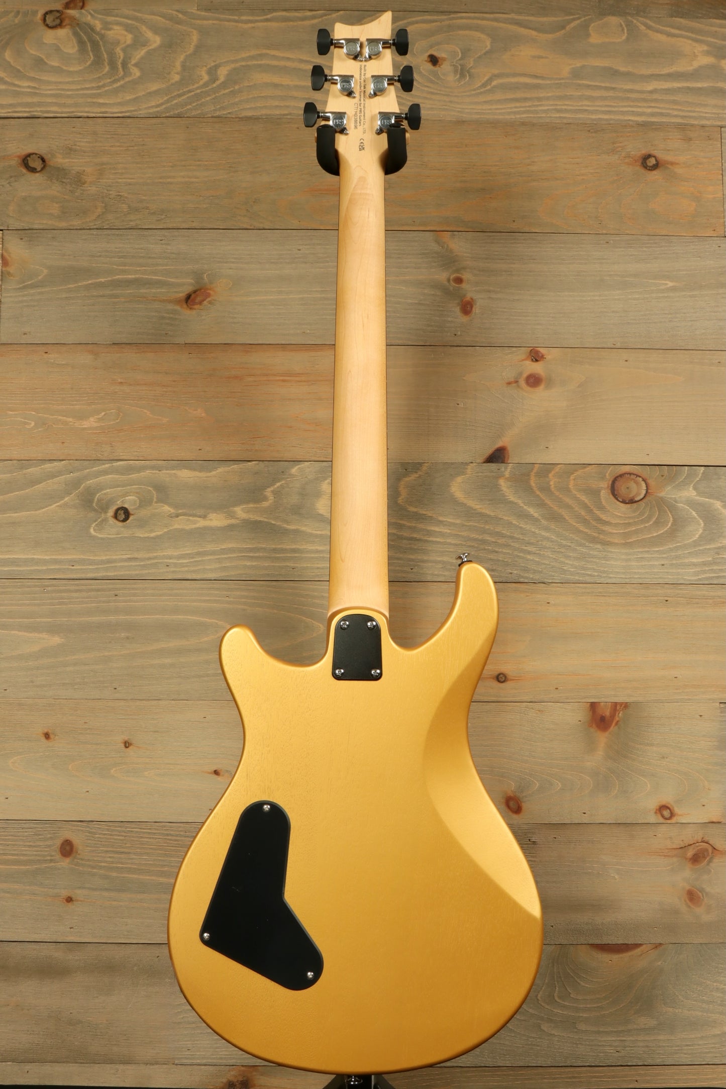 Back view of PRS SE CE24 Standard Stoptail guitar featuring a sleek golden finish and ergonomic design