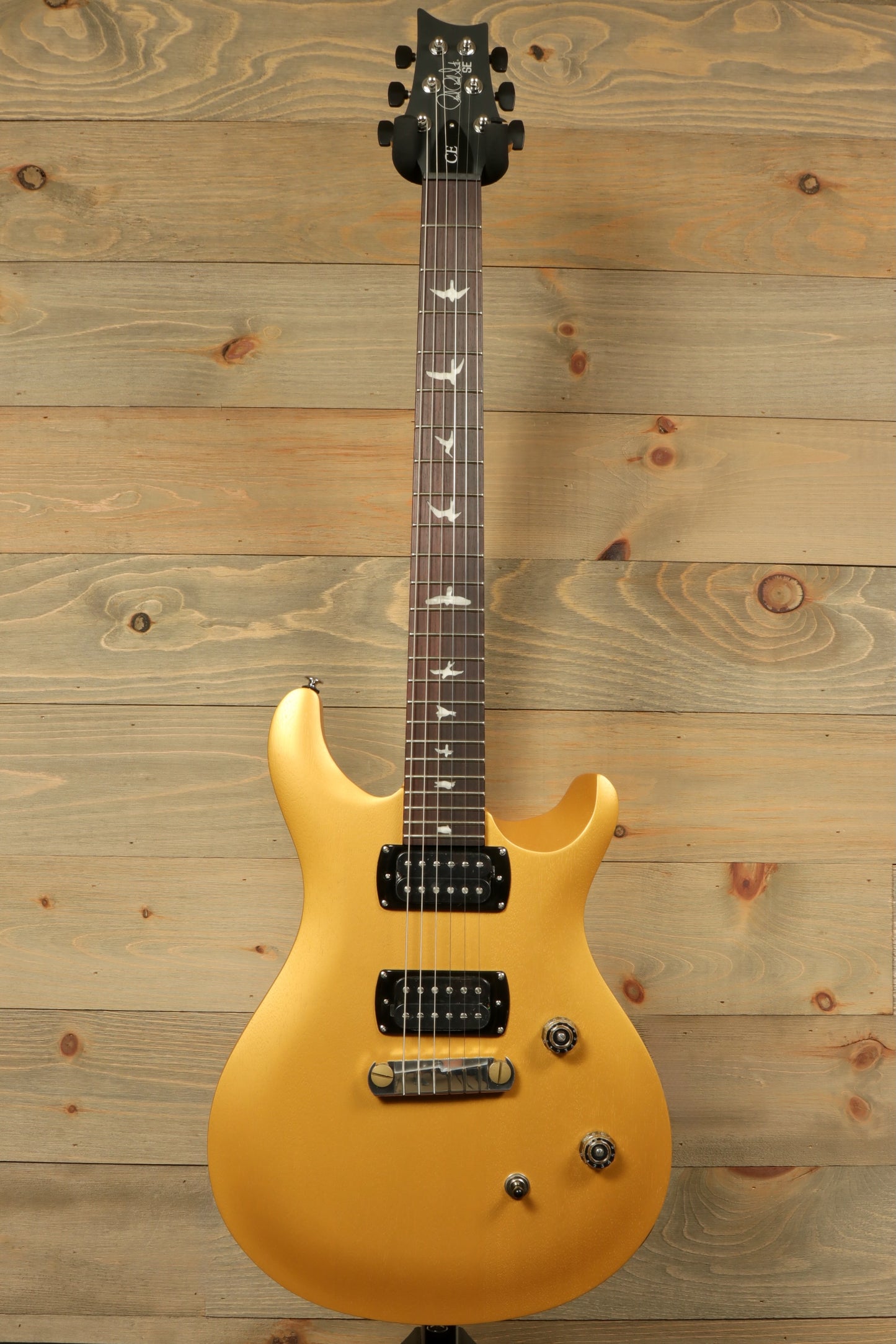 PRS SE CE24 Standard Stoptail guitar in gold finish with a sleek design and elegant inlays