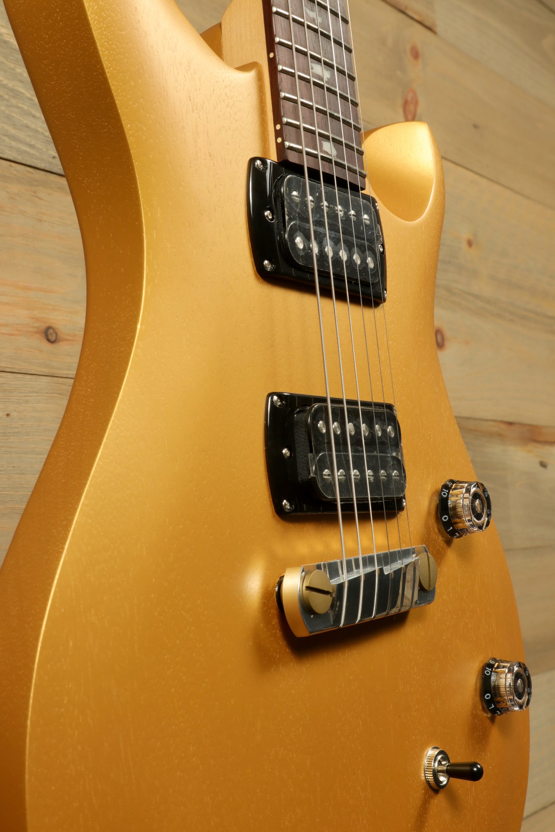PRS SE CE24 Standard Stoptail guitar in gold finish showcasing pickup and hardware details