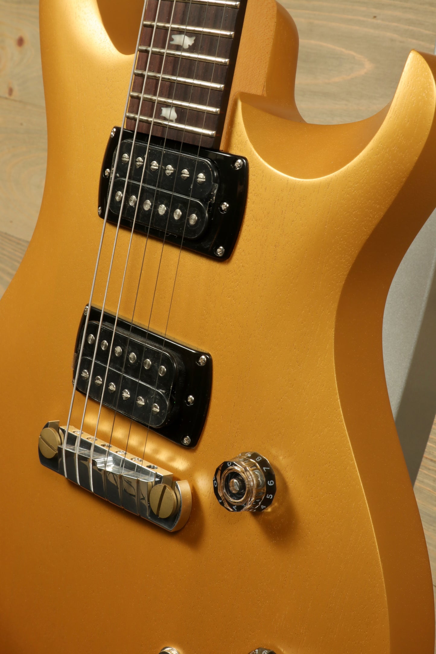 PRS SE CE24 Standard Stoptail guitar in gold finish showcasing pickups and controls
