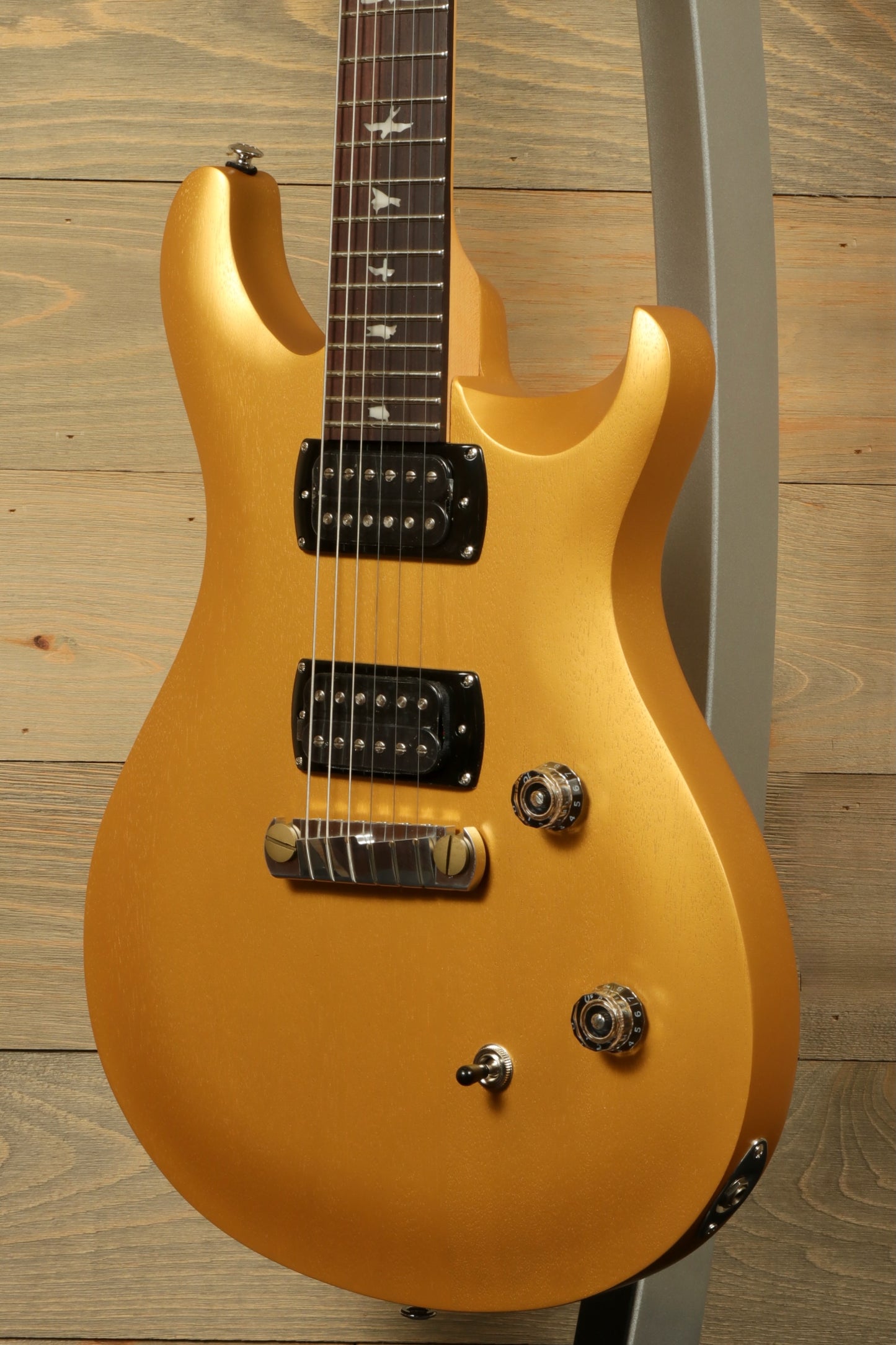 PRS SE CE24 Standard Stoptail guitar in gold finish with sleek design and powerful pickups