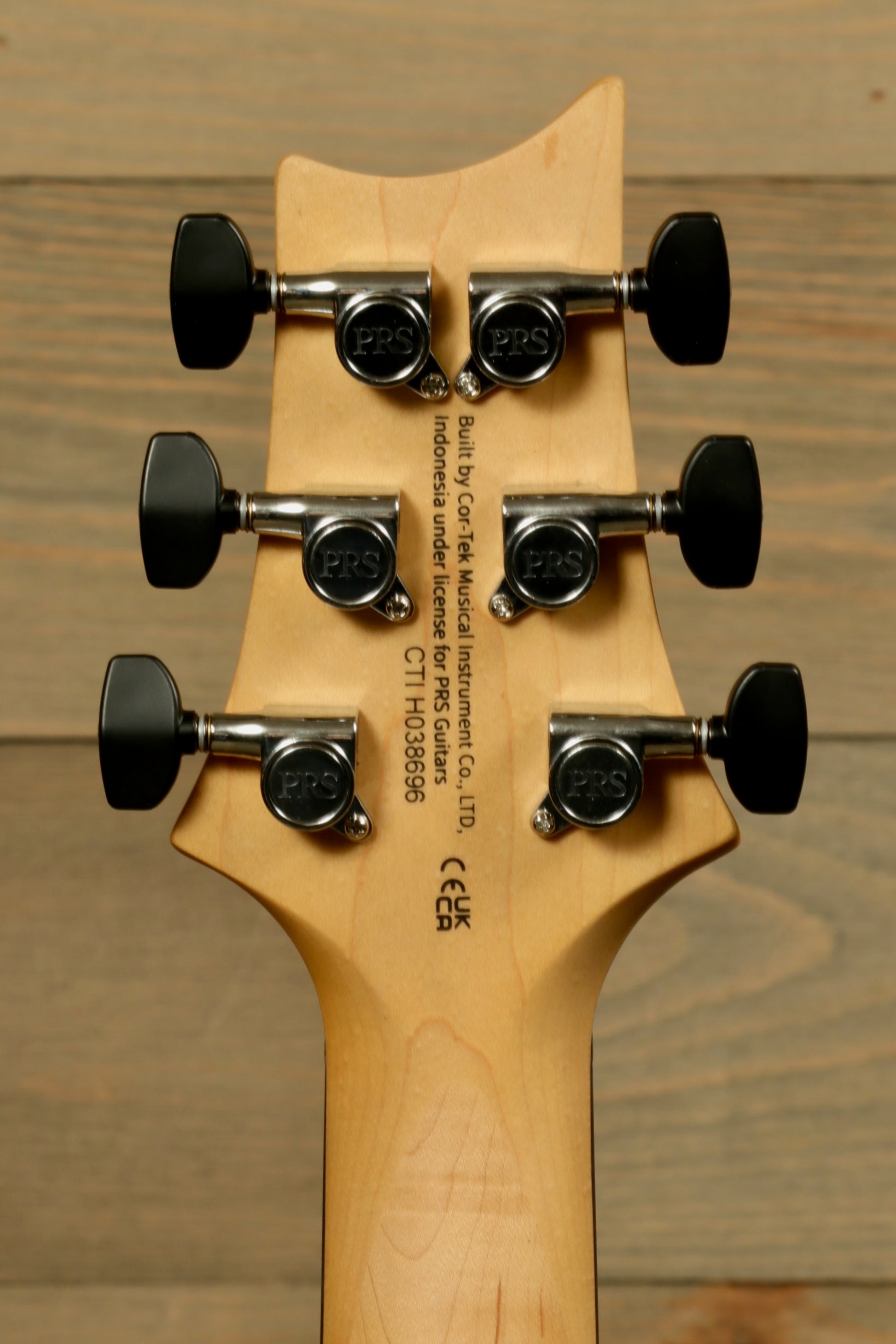 Back view of PRS SE CE24 Standard Stoptail guitar headstock with six tuning pegs for precise tuning