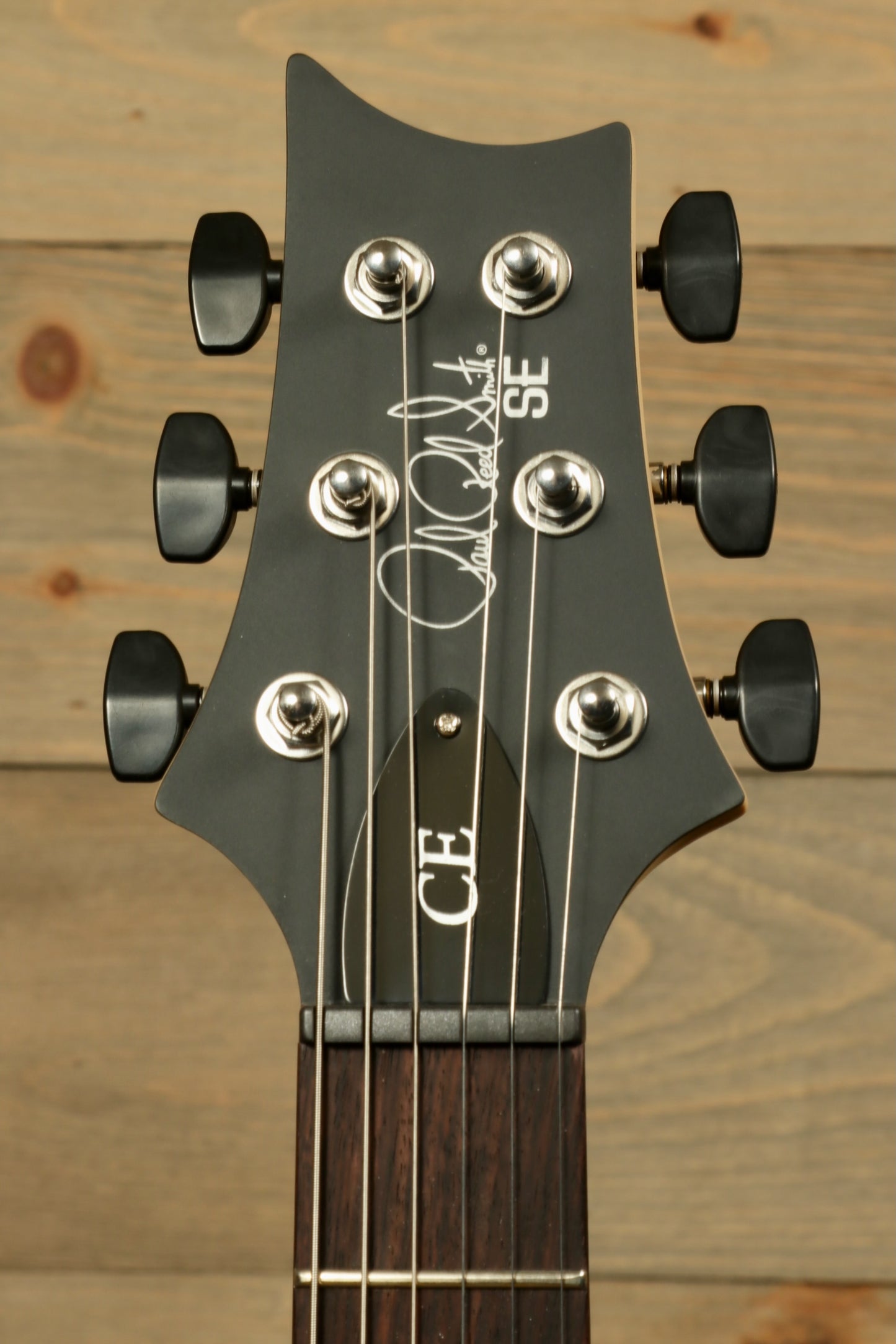 PRS SE CE24 Standard Stoptail guitar headstock with chrome tuning pegs and signature detail