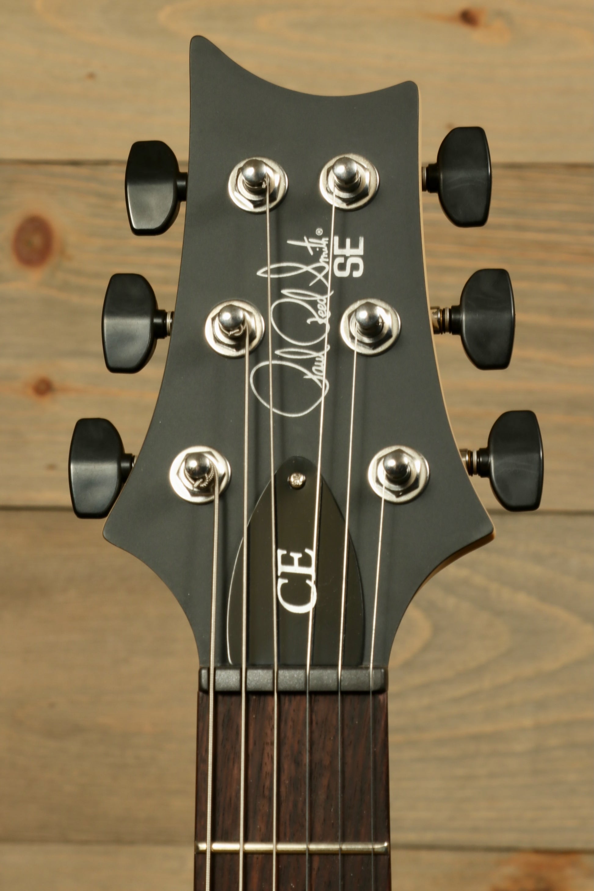 PRS SE CE24 Standard Stoptail guitar headstock with chrome tuning pegs and signature detail