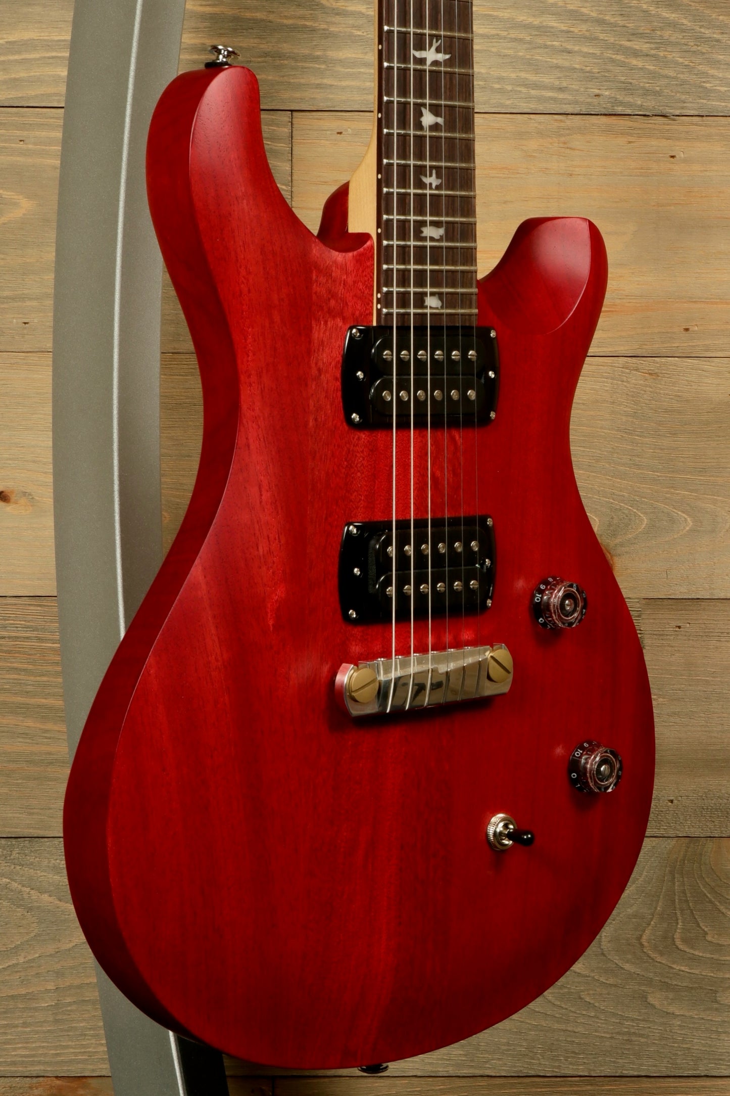 PRS SE CE24 Standard Stoptail guitar in a vibrant red finish with a sleek body design