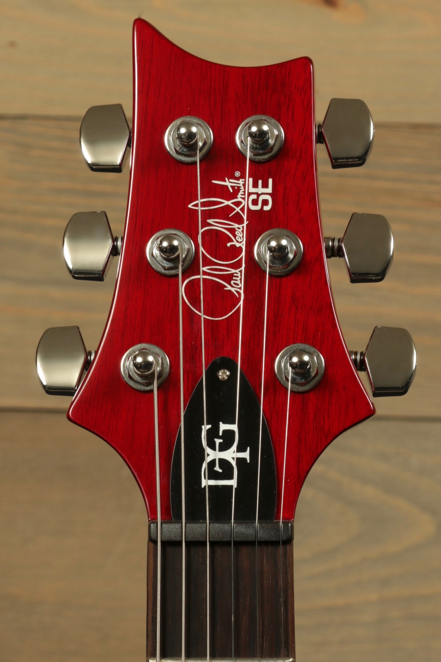 Close-up of PRS SE DGT Standard guitar headstock with signature and tuning pegs