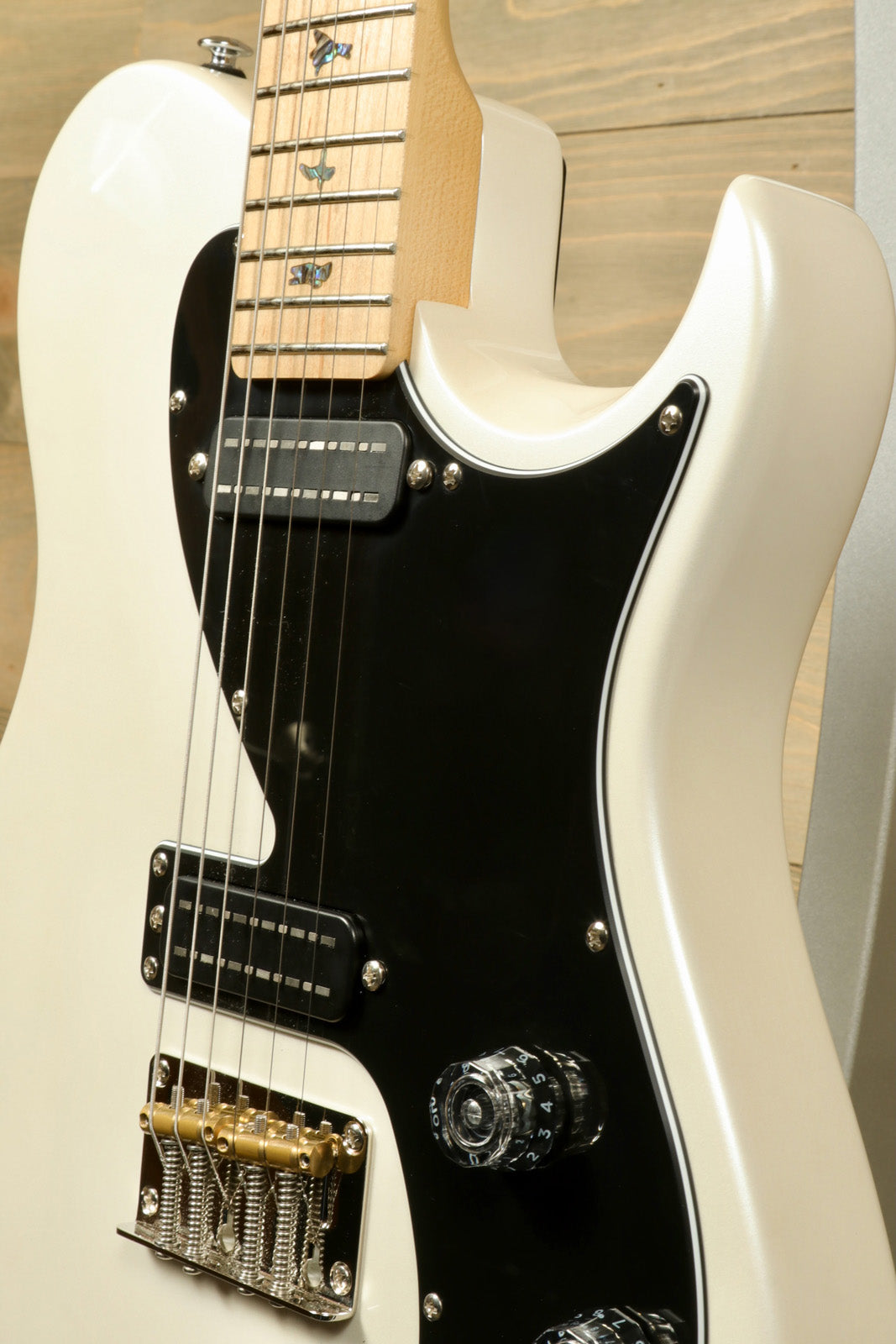 PRS SE NF53 white electric guitar with black pickguard, close-up view