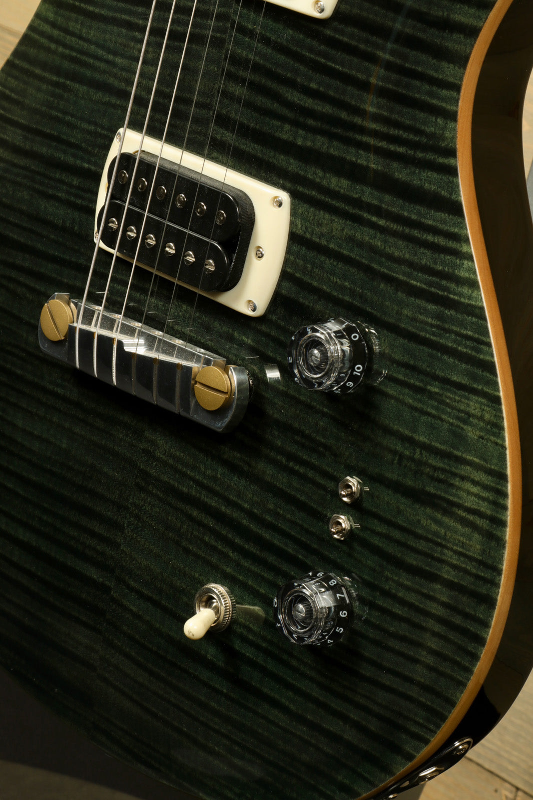 PRS SE Paul's Guitar in green burst finish, showing pickups and control knobs, angled view