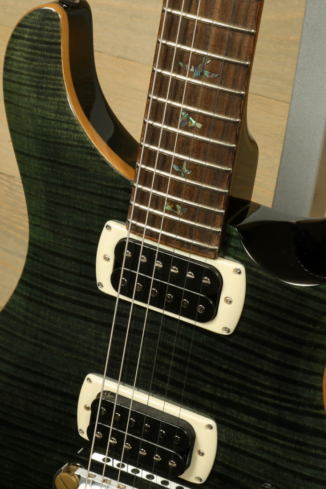 PRS SE Paul's Guitar in emerald green finish, showcasing the neck and pickups from the front view