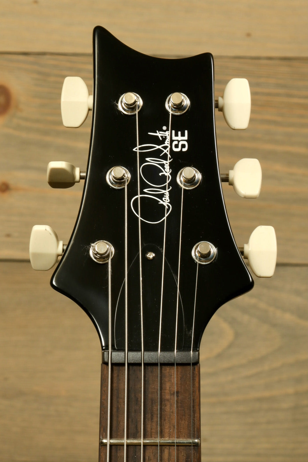 PRS SE Paul's Guitar, black headstock with signature and chrome tuning pegs, front view