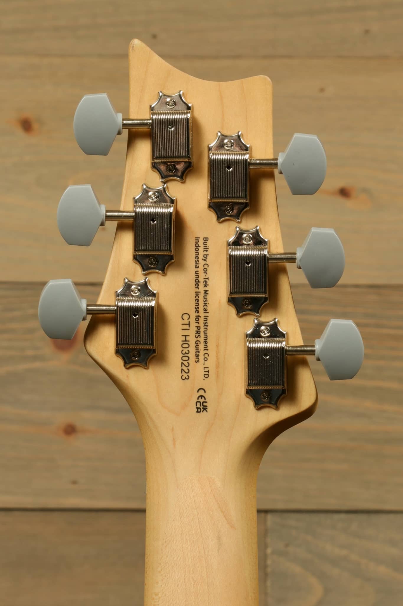 Rear view of the PRS SE Silver Sky - Moon White guitar headstock showing tuning pegs and natural wood finish