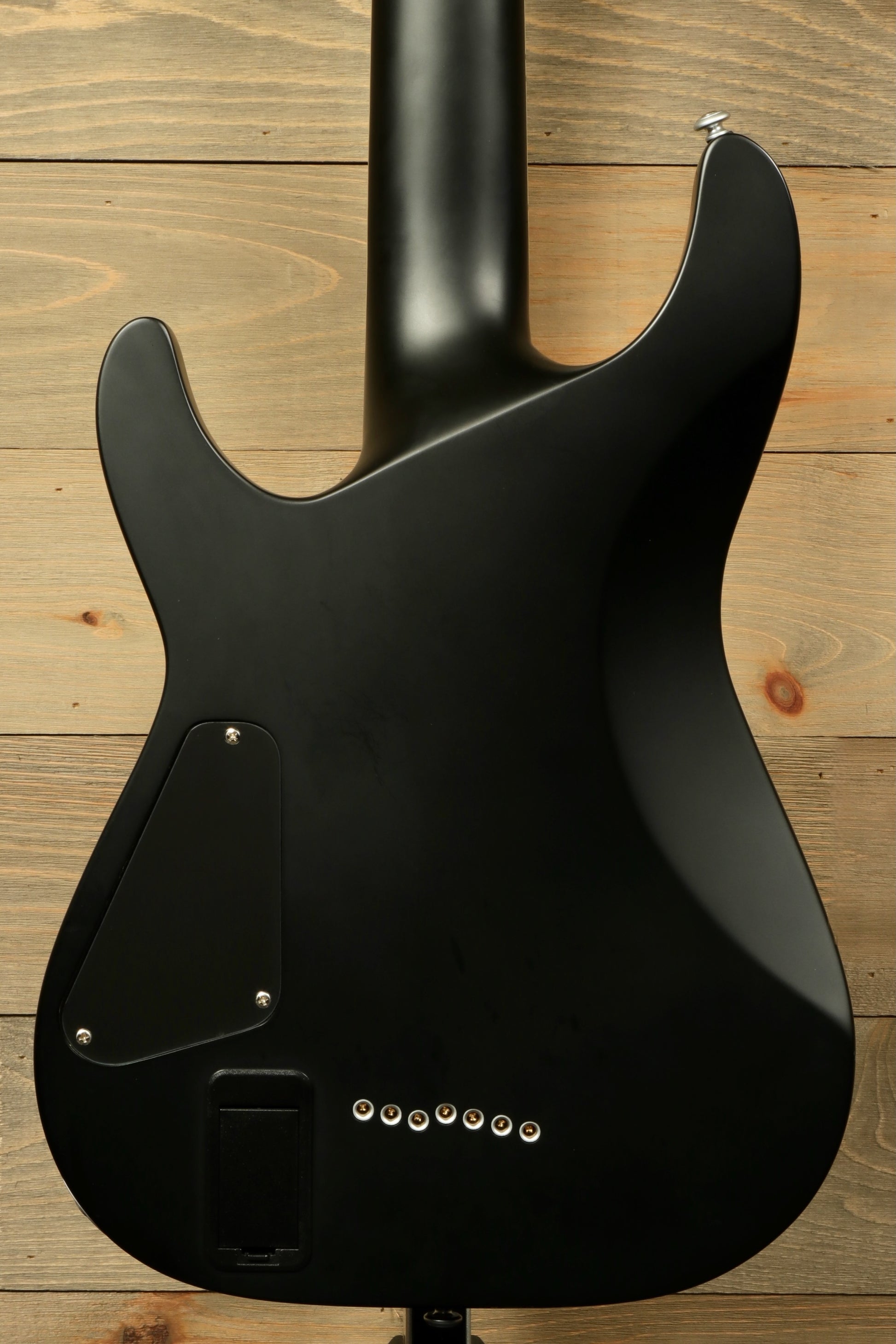 Back view of used Schecter Damien 7 Platinum guitar showcasing its sleek black finish and streamlined design