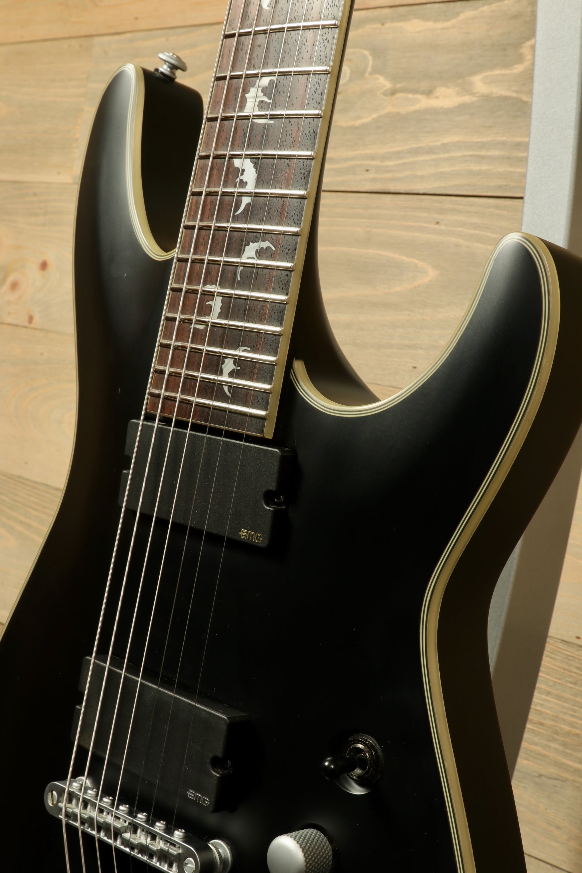 Close-up of a used Schecter Damien 7 Platinum guitar showcasing the sleek neck and fretboard details