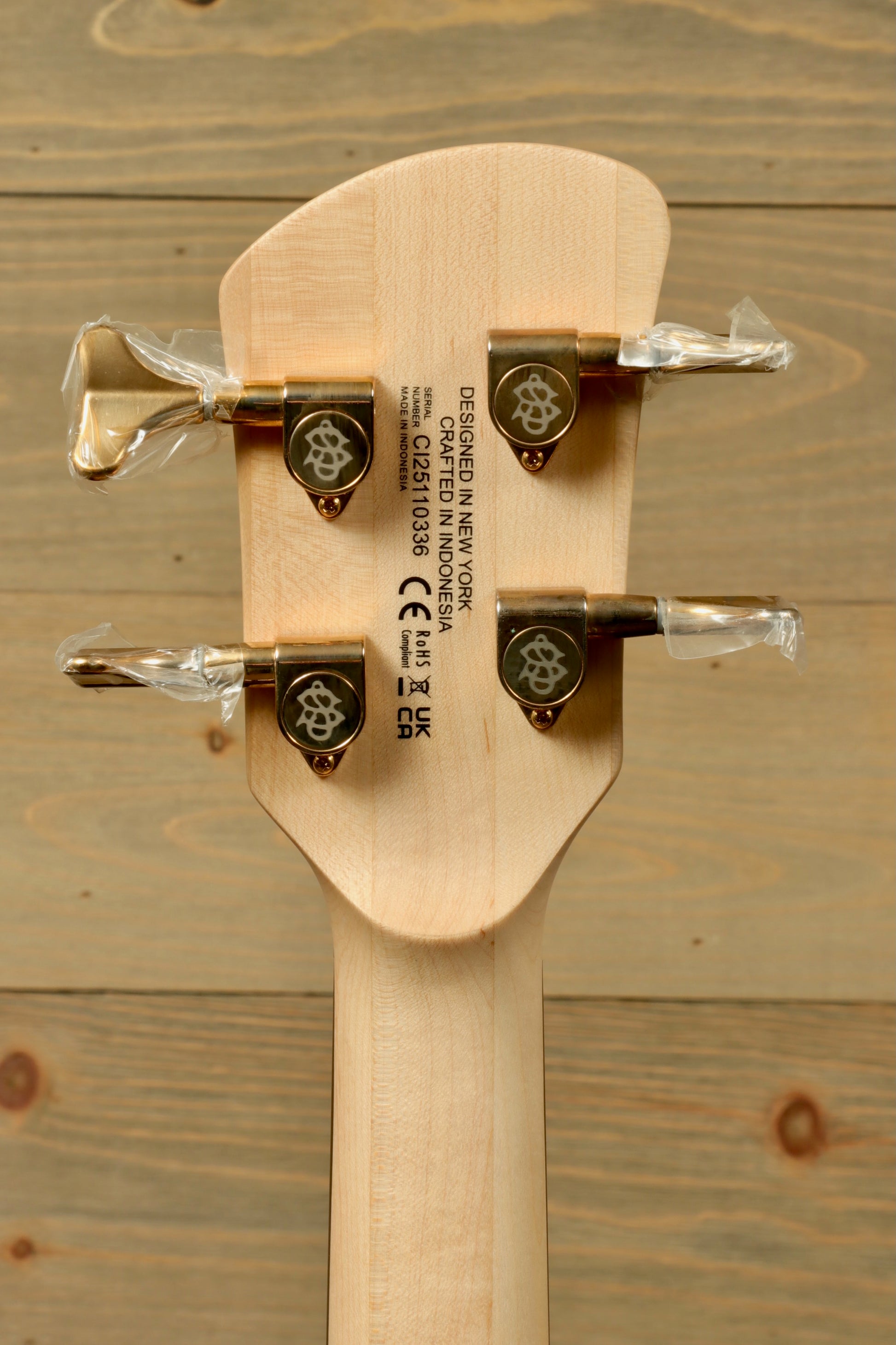 Close-up of the headstock of the Spector ICON NS-2 bass guitar with tuning pegs and logo