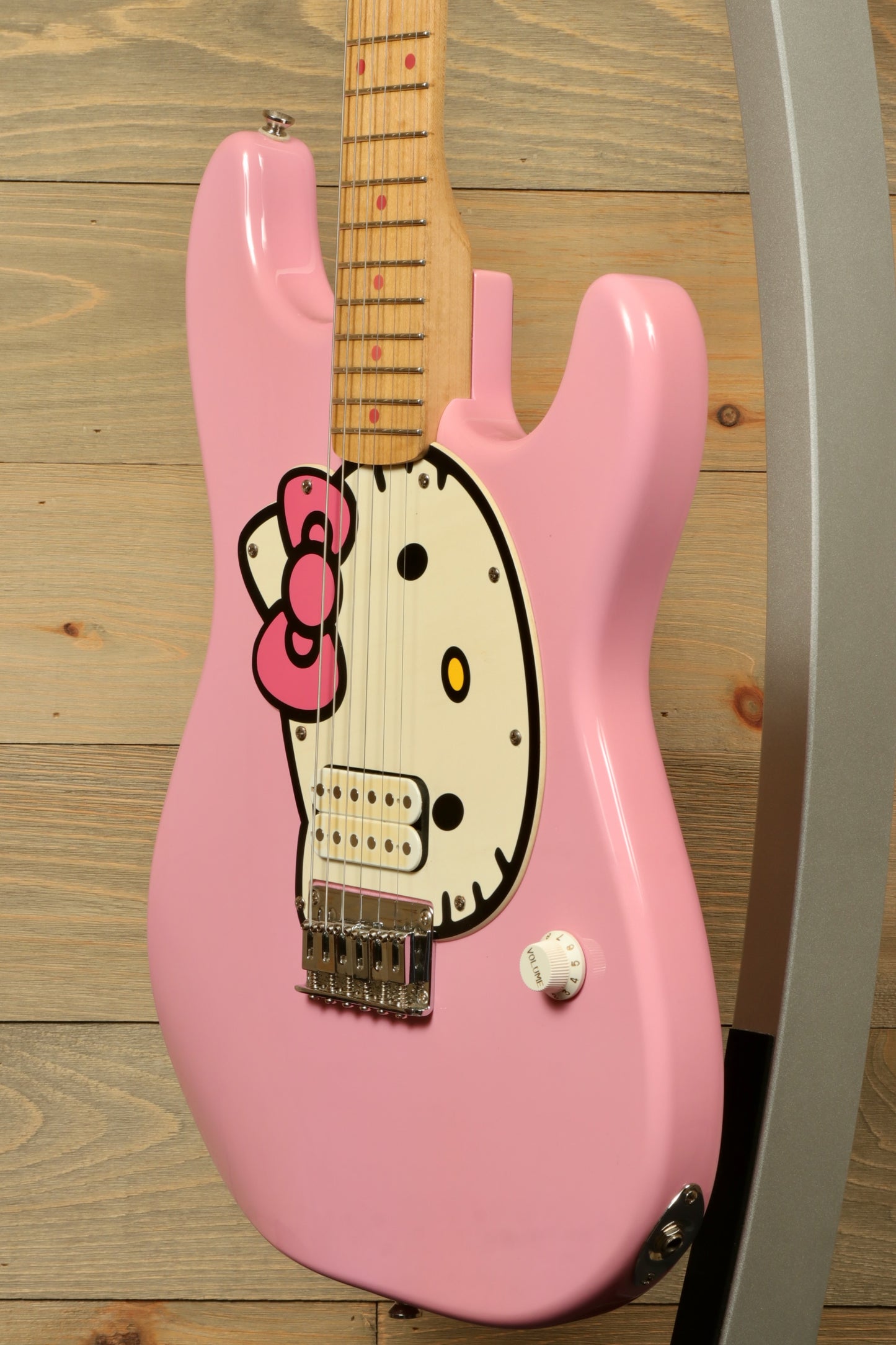 2006 Squier Hello Kitty Stratocaster in pink with Hello Kitty design, side view on display stand