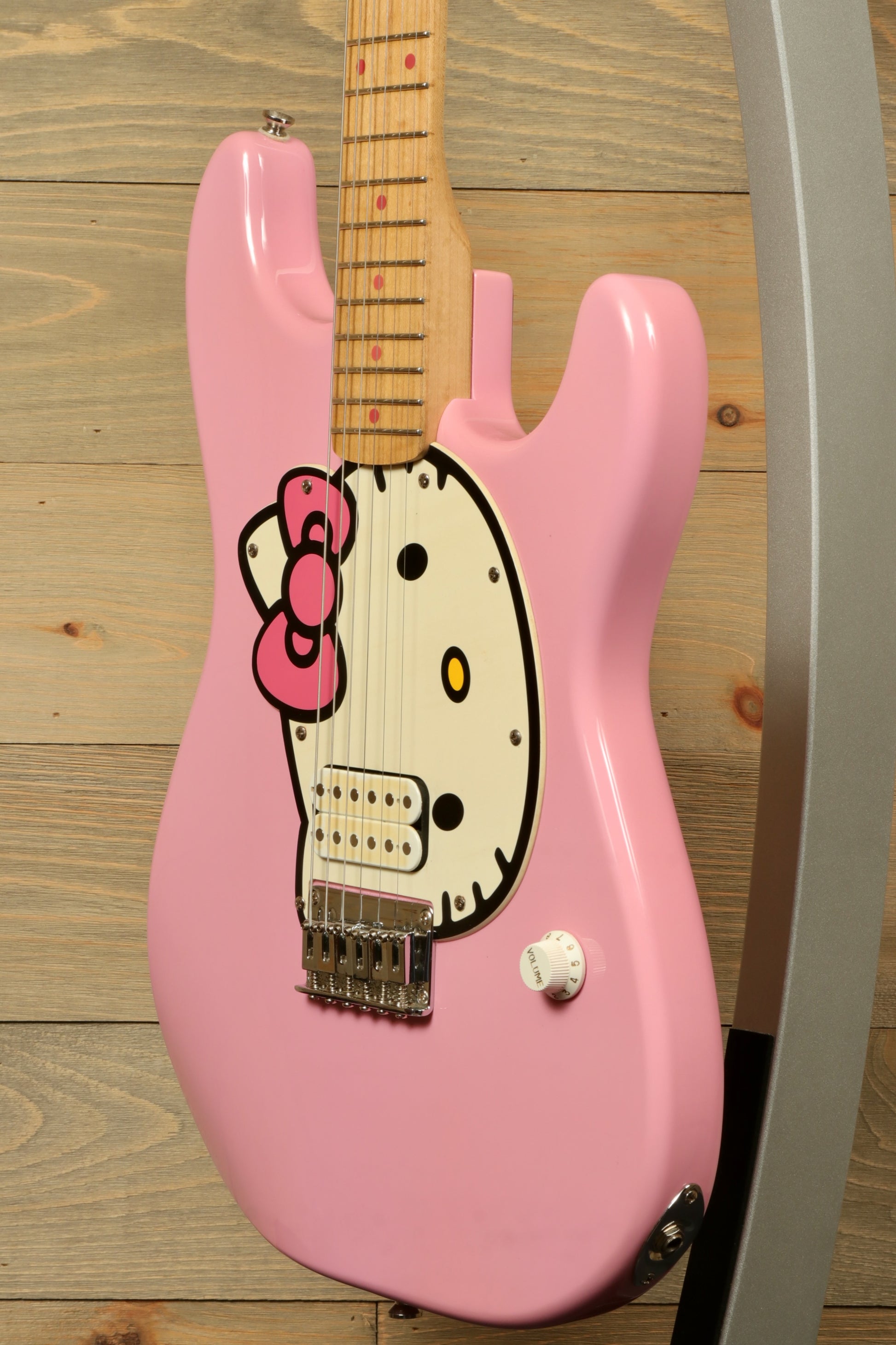 2006 Squier Hello Kitty Stratocaster in pink with Hello Kitty design, side view on display stand