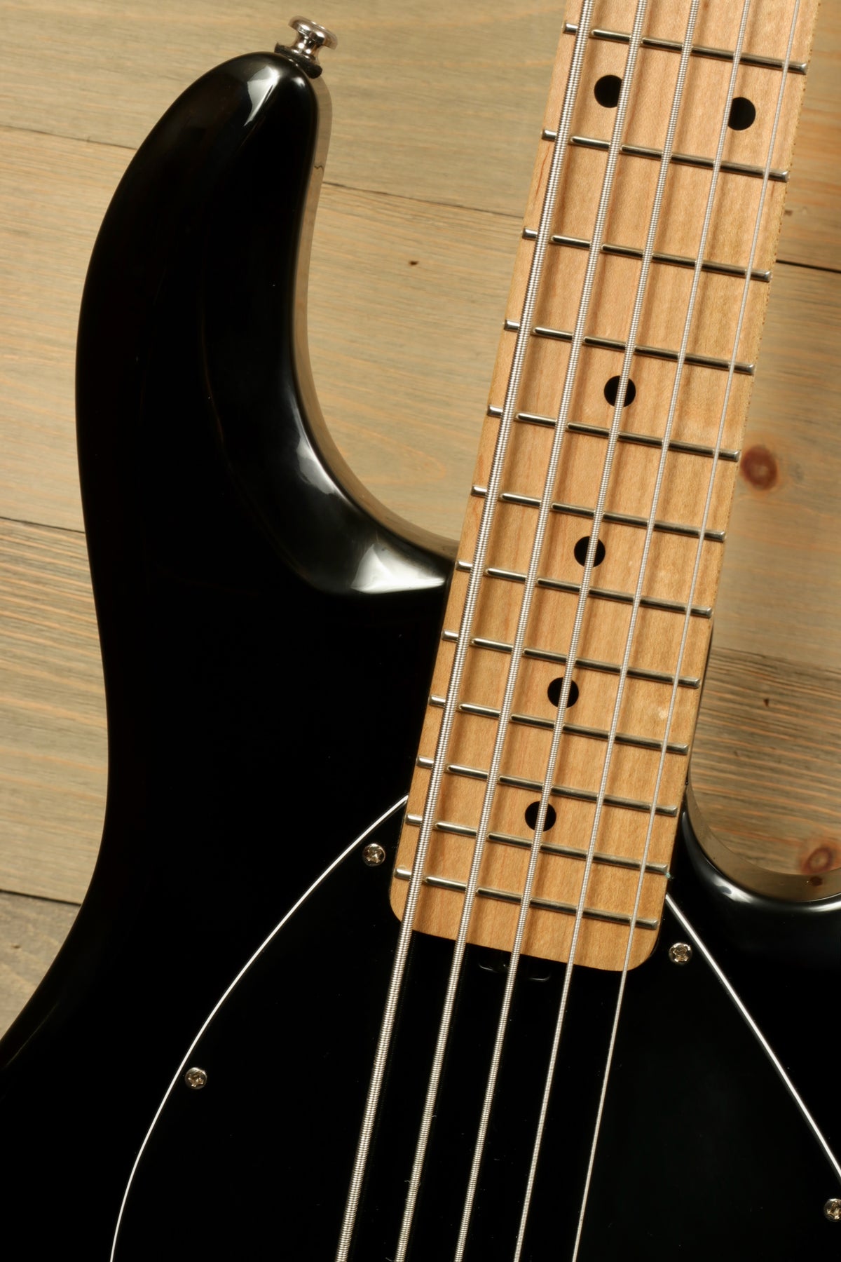 Sterling by Music Man active 5 string bass guitar in black, close-up view of the neck