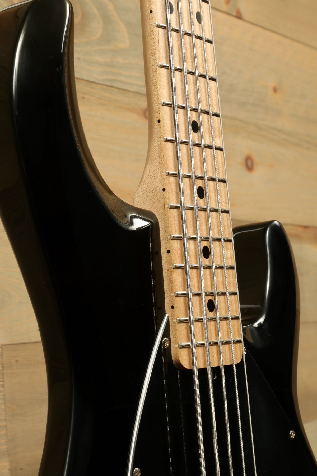 Sterling by Music Man used active 5 string bass guitar in black, side view showcasing the neck and frets