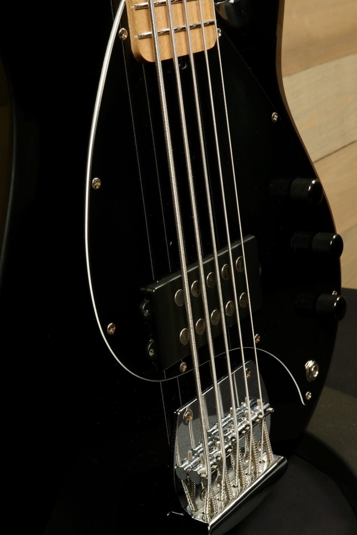 Sterling by Music Man used active 5 string bass in black, showcasing the bridge and pickups from the side view.