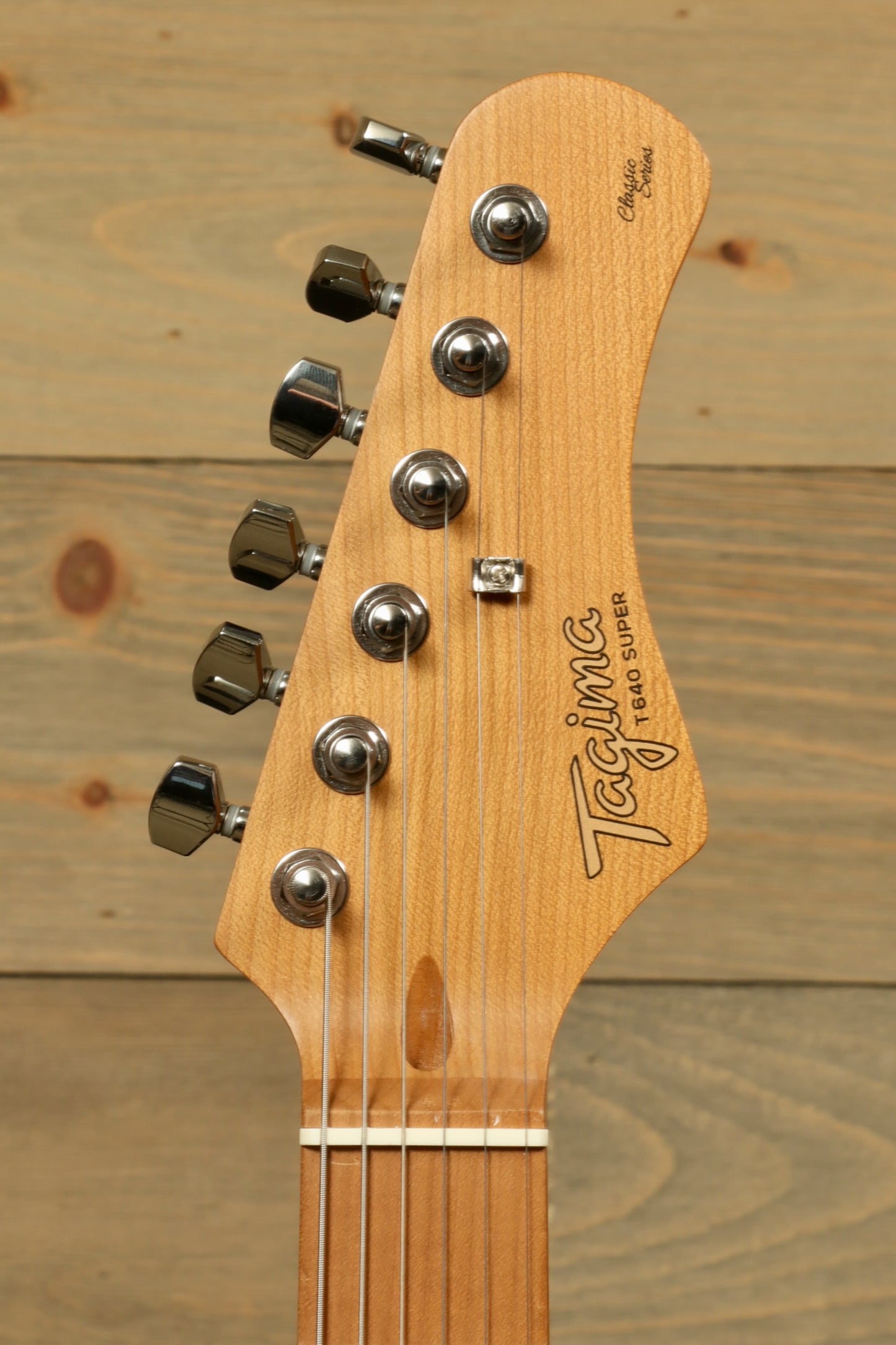 Tagima TG-600 Super electric guitar headstock with natural wood finish, front view