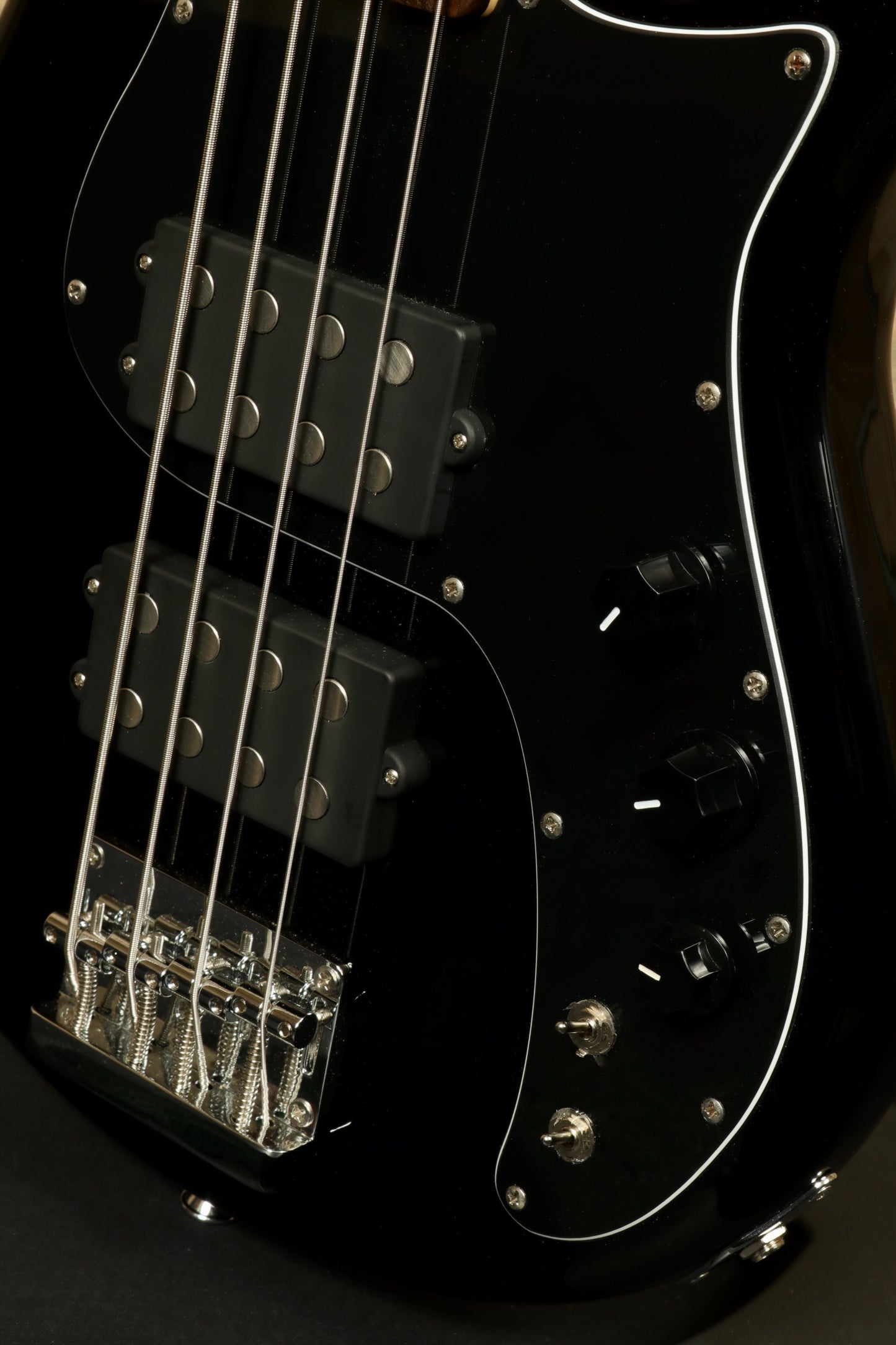 Close-up of Tagima Fusion-4 H2 bass guitar featuring black body and chrome hardware