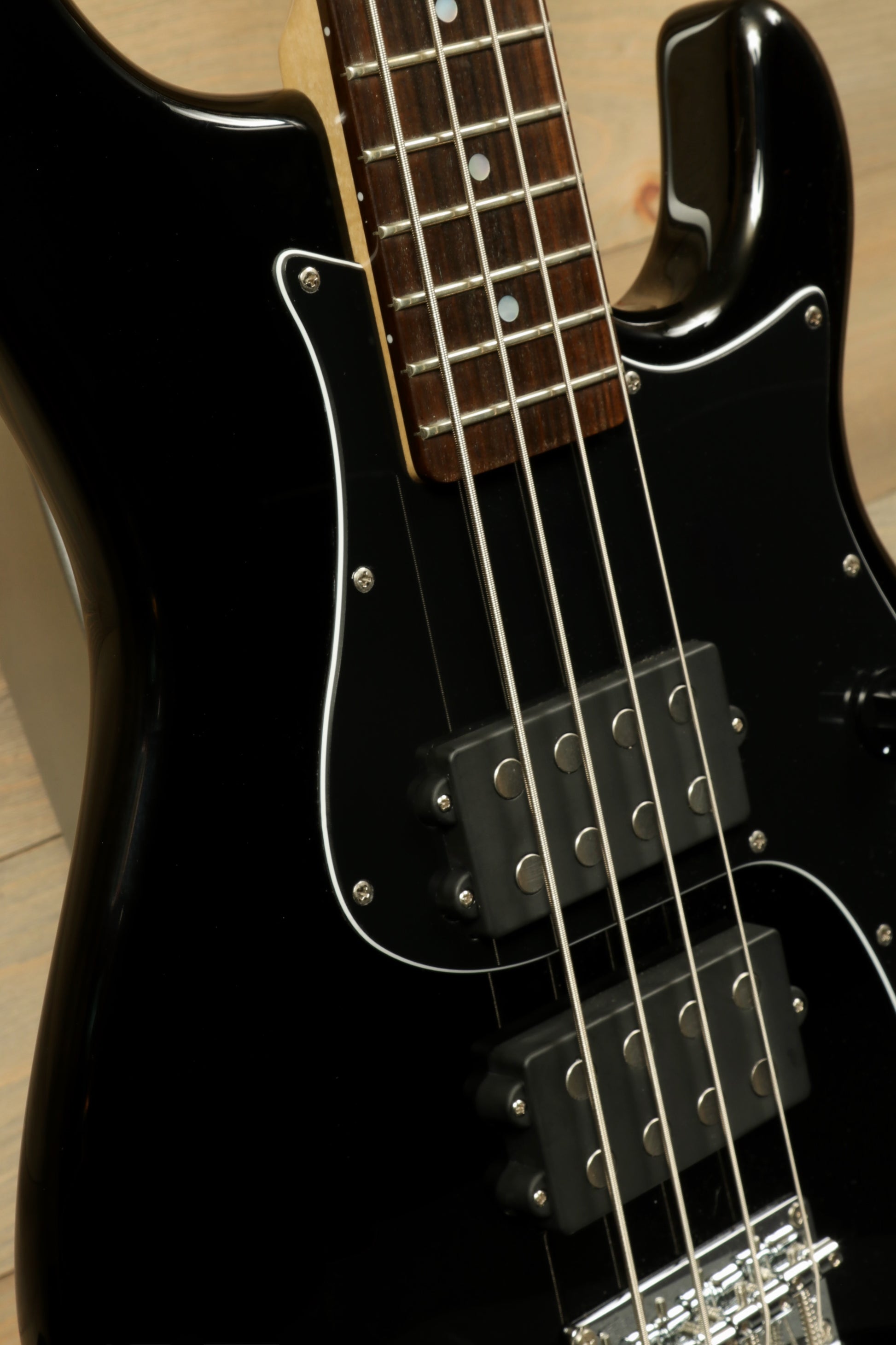 Close-up of Tagima Fusion-4 H2 bass guitar showcasing black finish and dual pickups