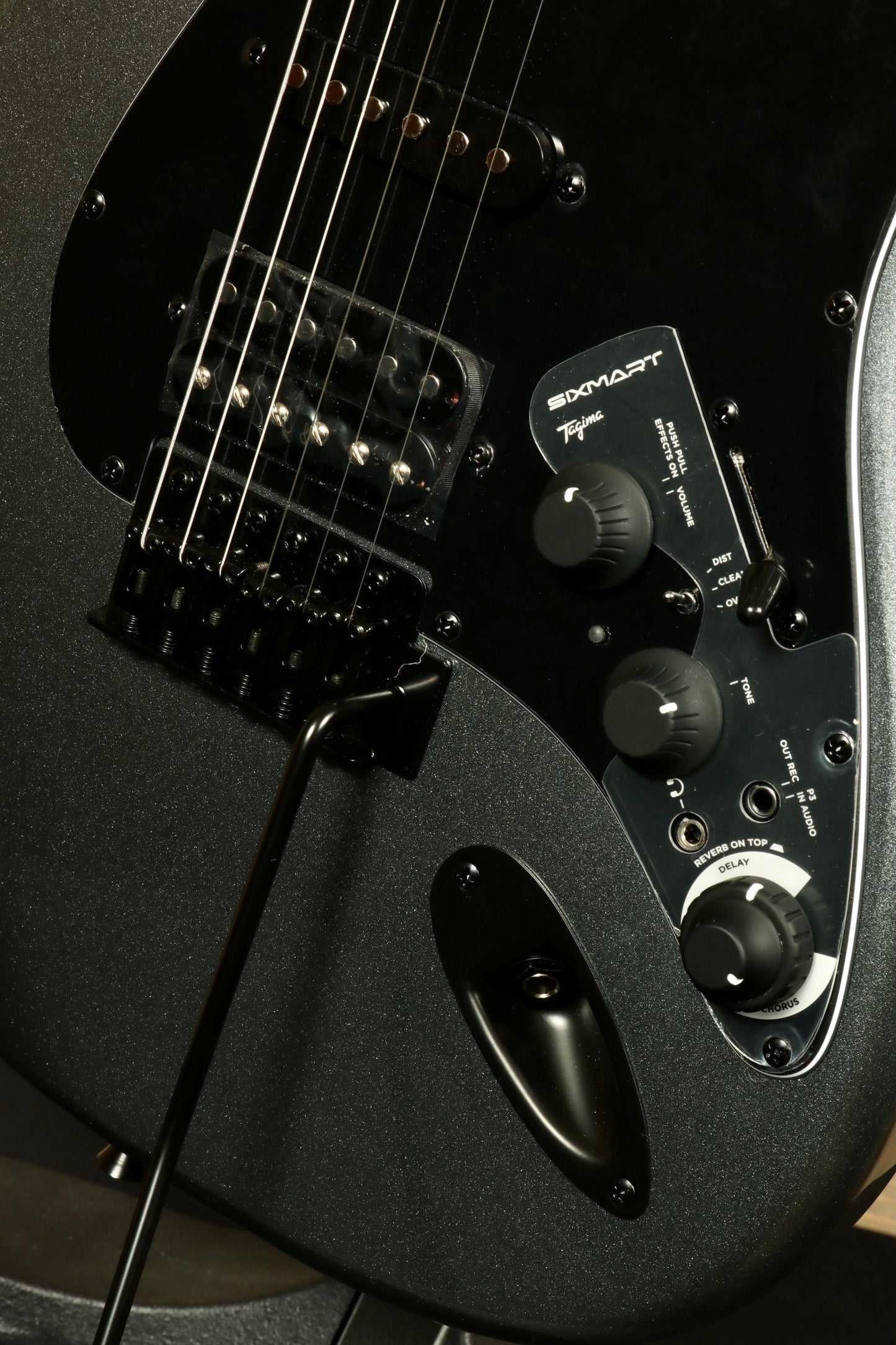 Close-up of Tagima Sixmart electric guitar featuring black finish and control knobs