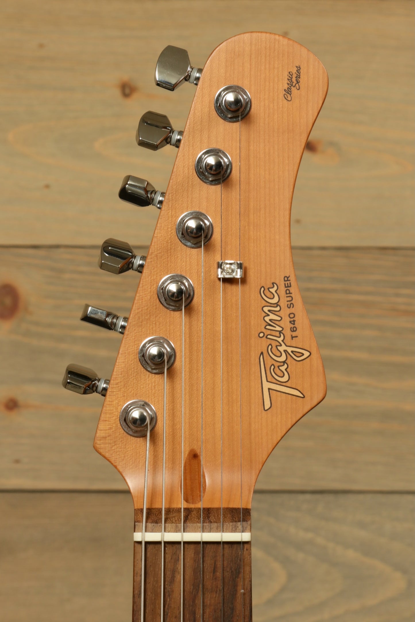 Tagima T 640 SUPER electric guitar in natural wood finish, showcasing headstock and tuning pegs