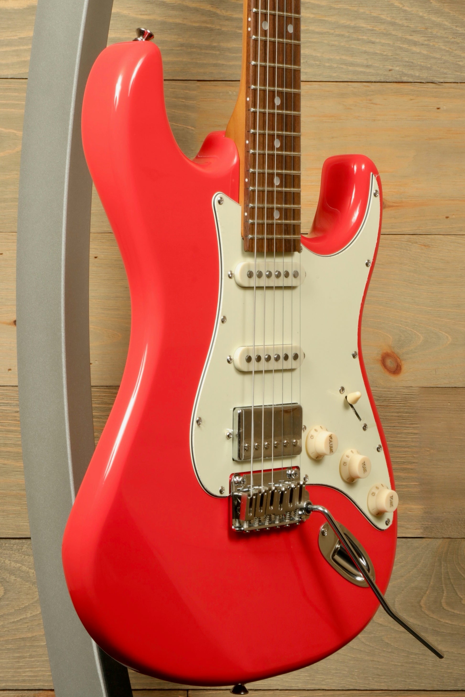 Tagima T 640 SUPER electric guitar in vibrant pink, side view on display