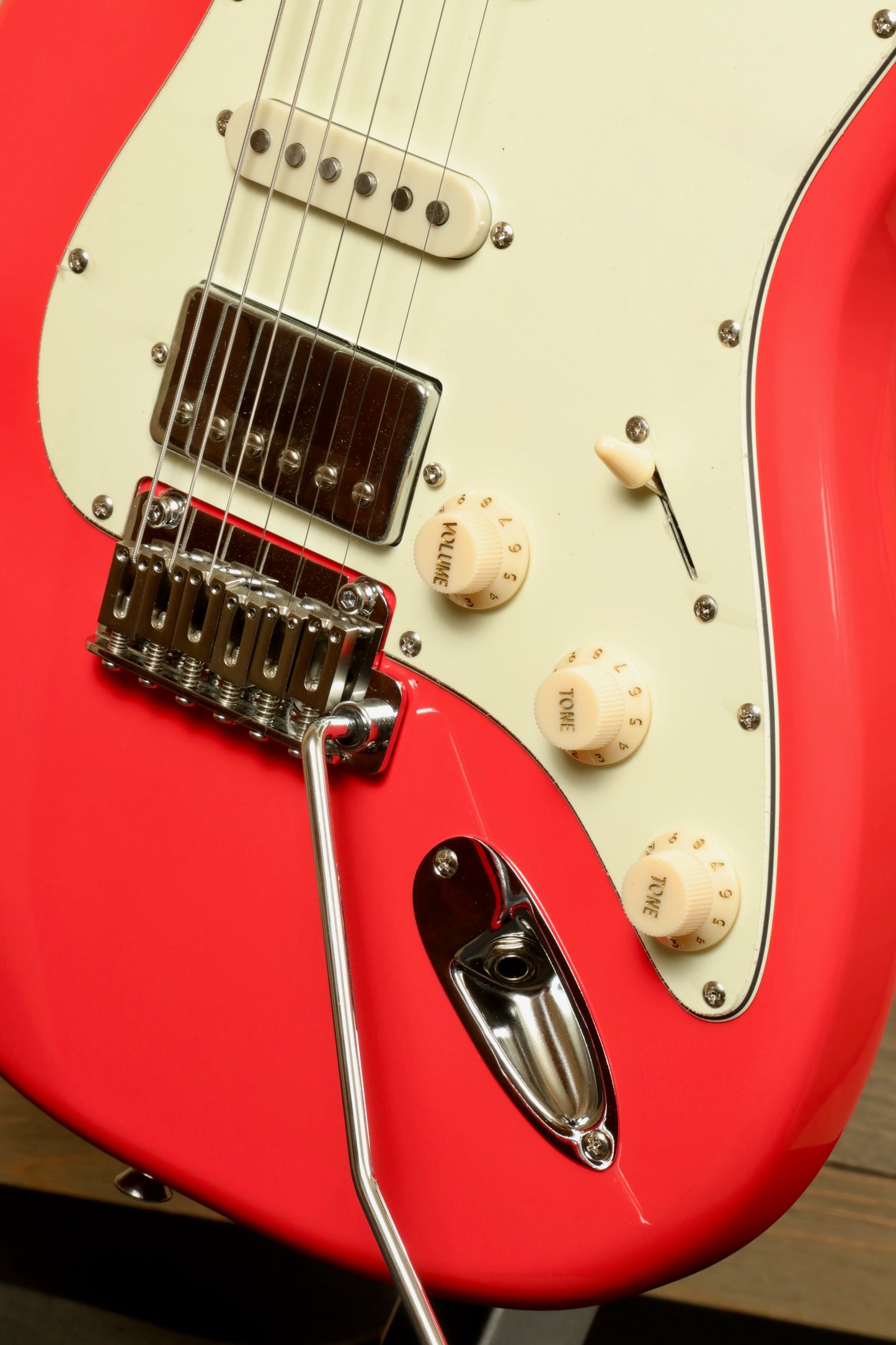 Tagima T 640 SUPER electric guitar in vibrant coral red, front close-up view highlighting the bridge and controls.