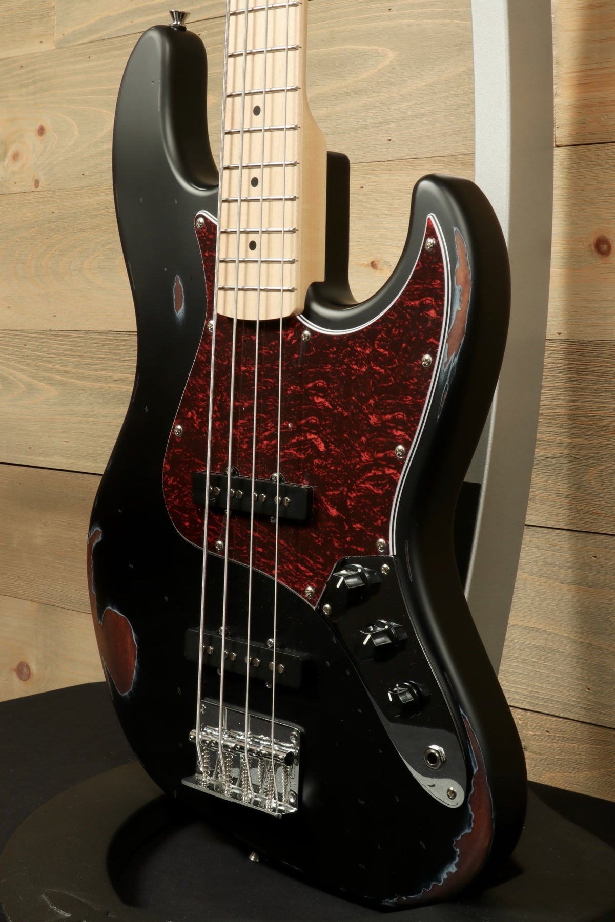 Tagima TBA-73 Electric Bass in black with a tortoiseshell pickguard, side view