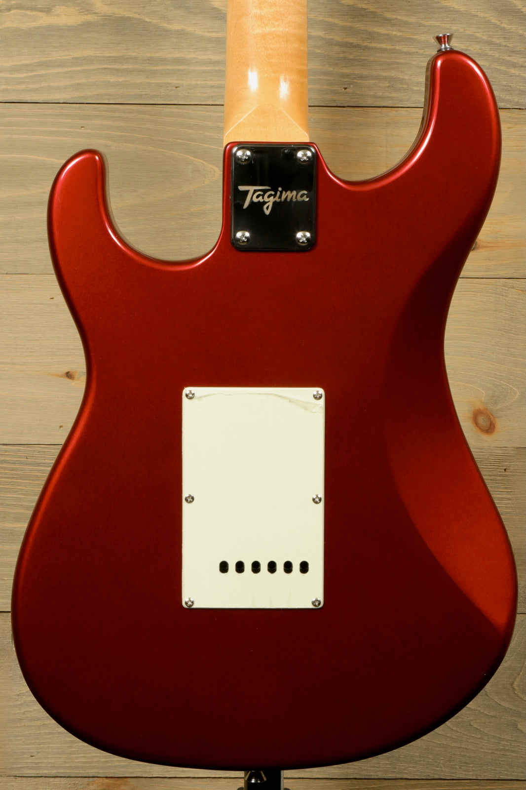 Back view of Tagima TG 540 electric guitar with vibrant red finish and smooth curves