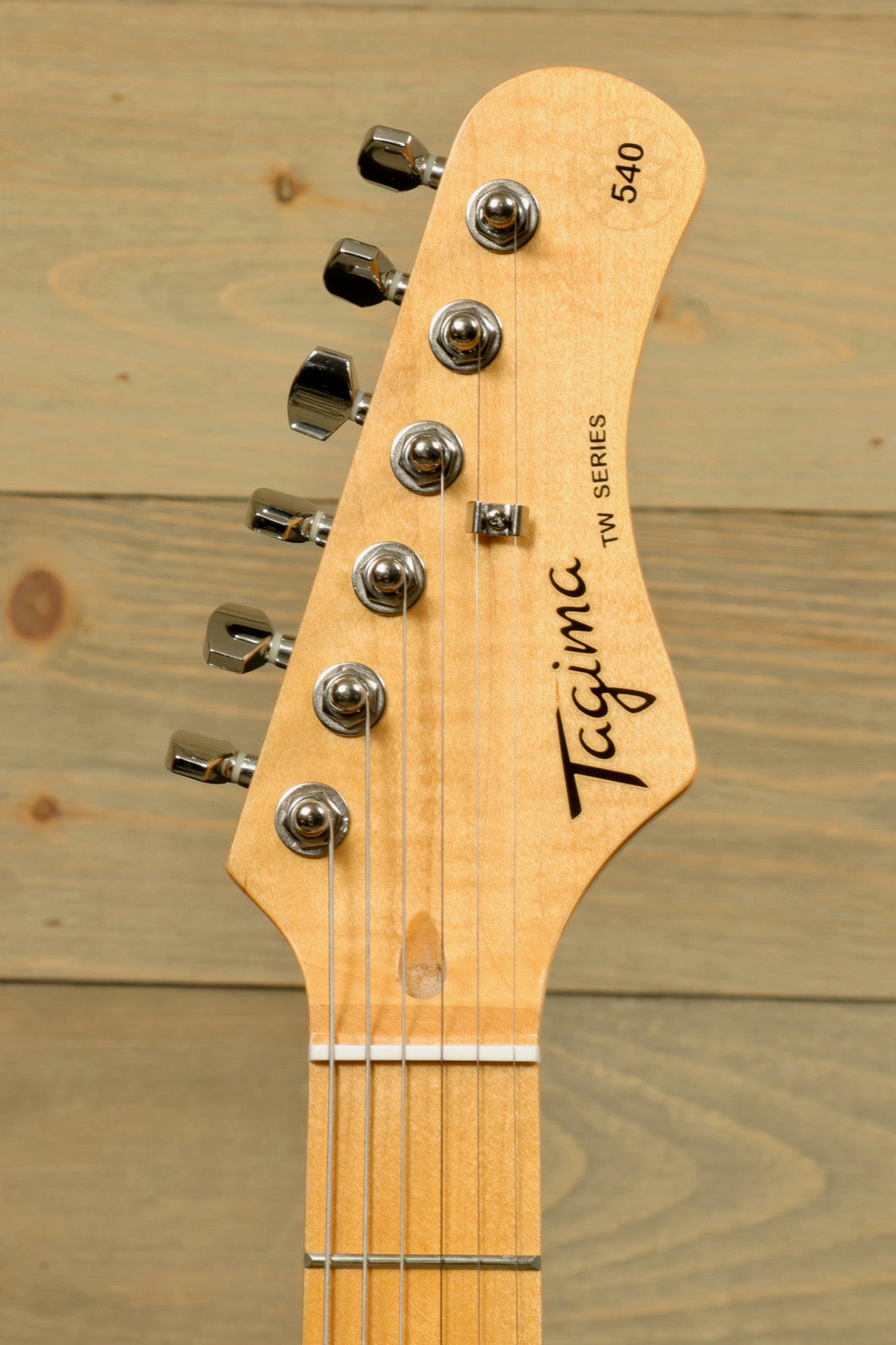 Tagima TG 540 electric guitar headstock with tuning pegs and strings, showcasing quality craftsmanship