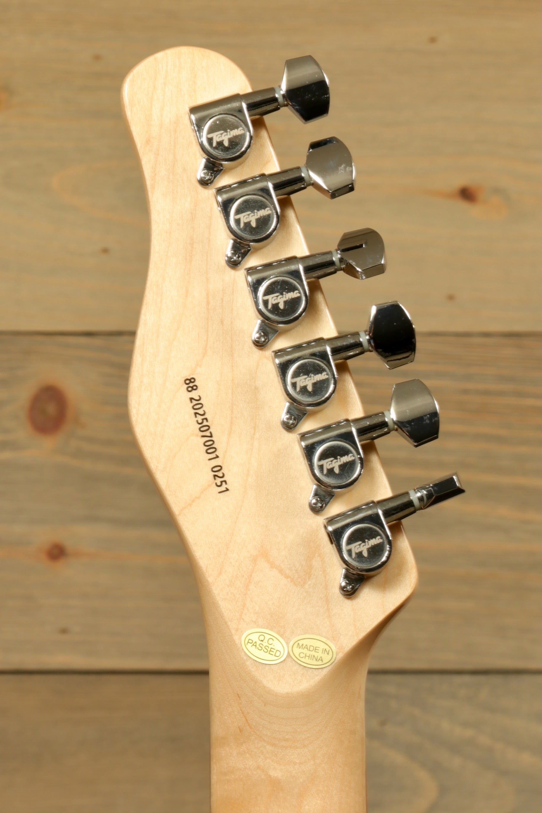 Tagima TW 55 MCBL/BK Electric Guitar headstock, showcasing chrome tuners and natural wood finish