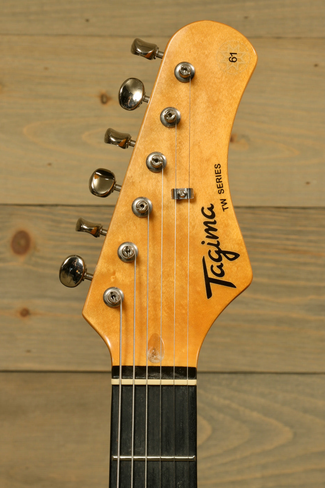 Tagima TW 61 Fiesta Red electric guitar headstock with tuning pegs and logo