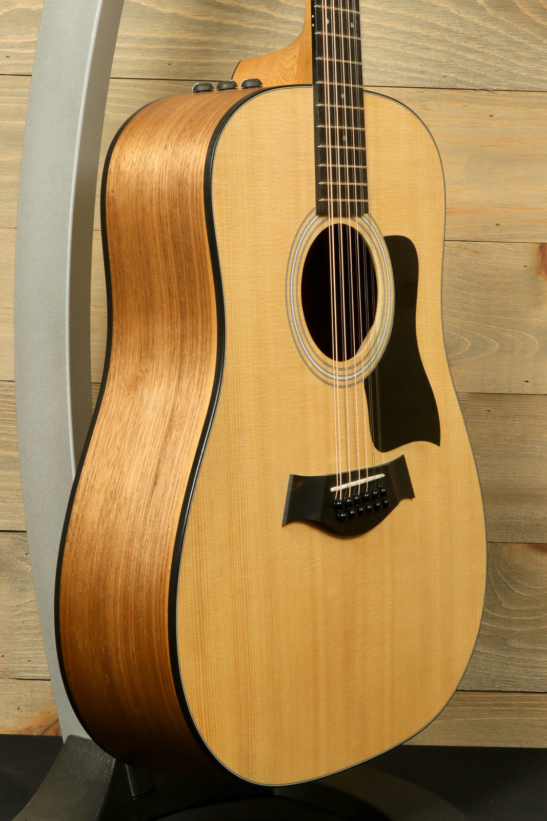Taylor 150e - USED acoustic electric guitar with natural finish, side view showcasing the wood grain