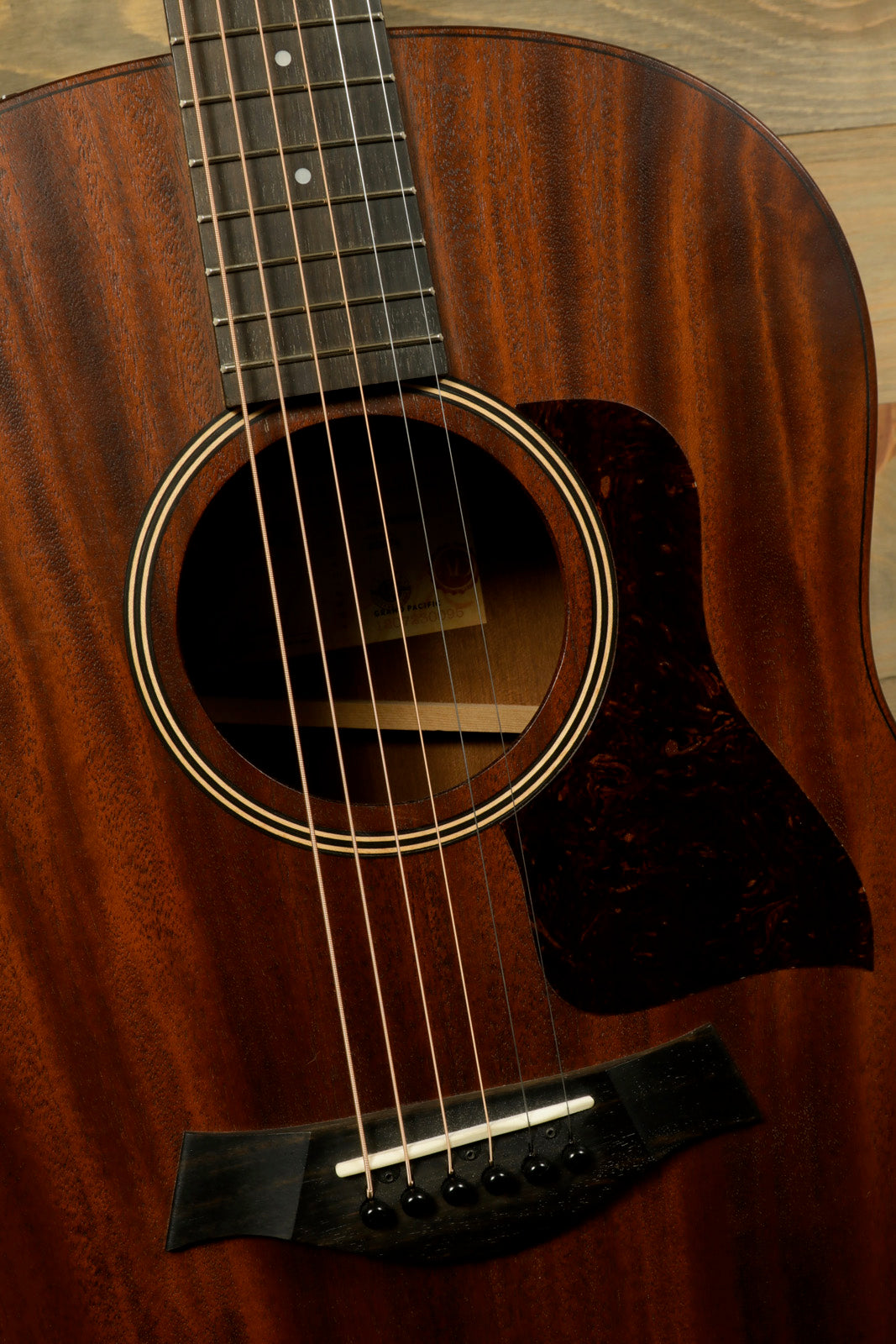 Taylor AD27e with Aerocase, natural wood finish, front view showcasing the soundhole and strings