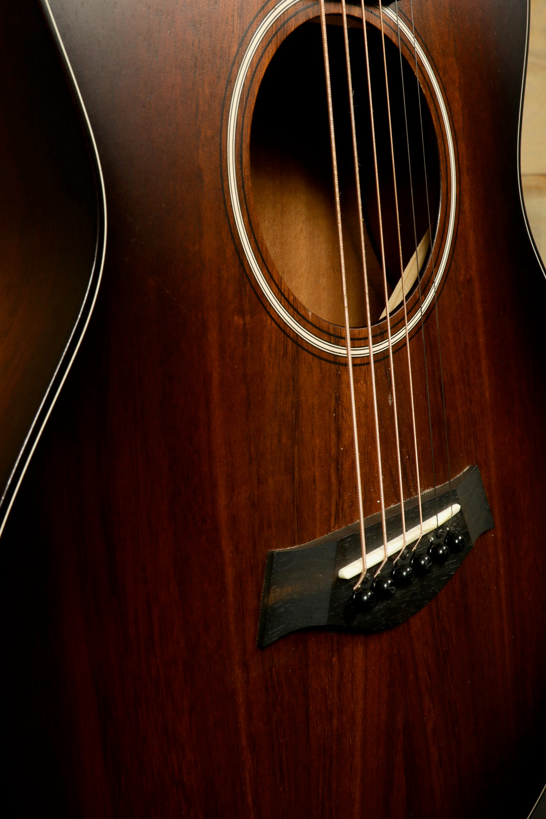 Taylor GS Mini-e Koa acoustic electric guitar, natural wood finish, close-up view of body and strings