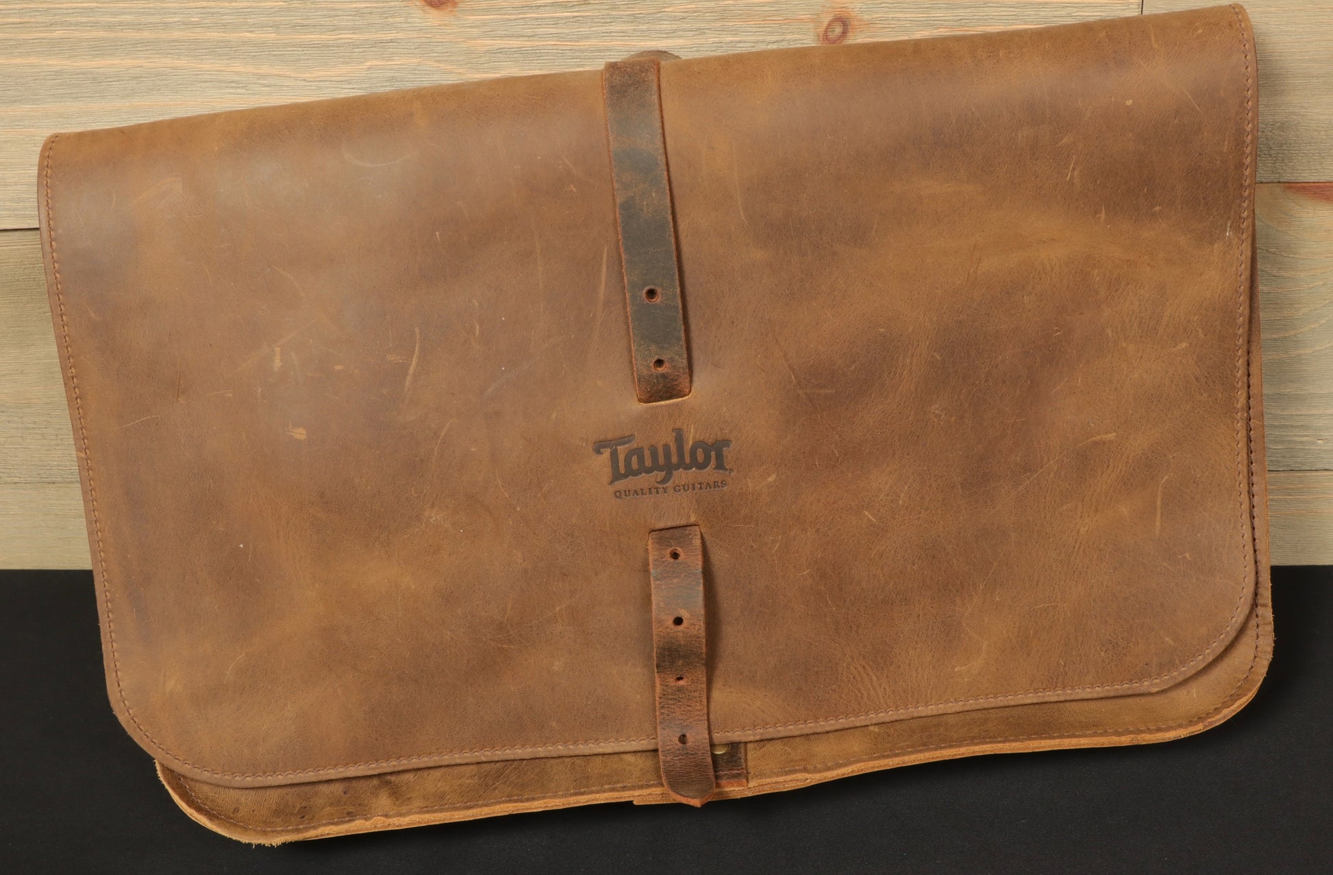Taylor Guitars messenger bag in tan leather with a classic buckle closure for stylish storage