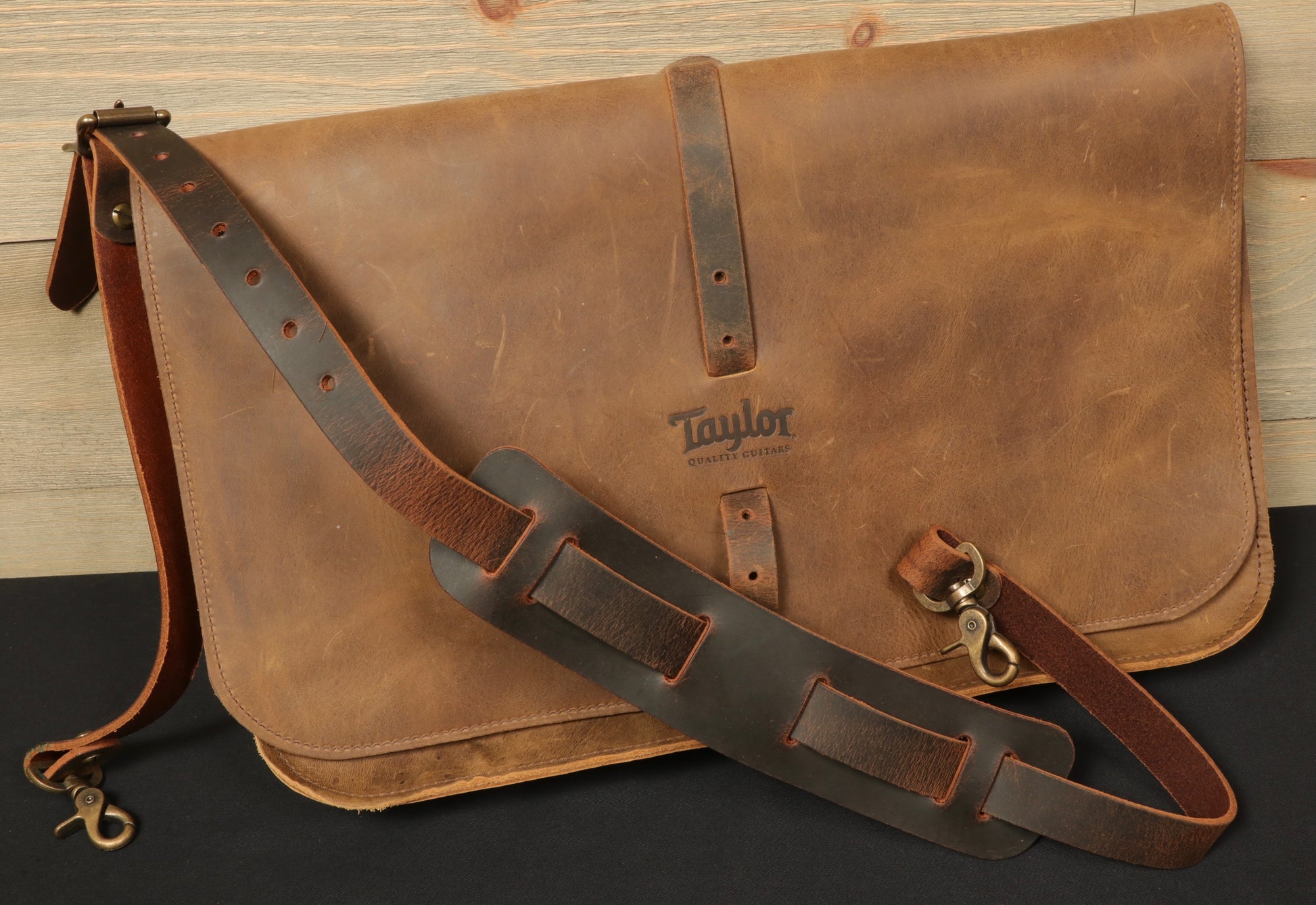 Stylish Taylor Guitars messenger bag in distressed leather with an adjustable strap for easy carrying