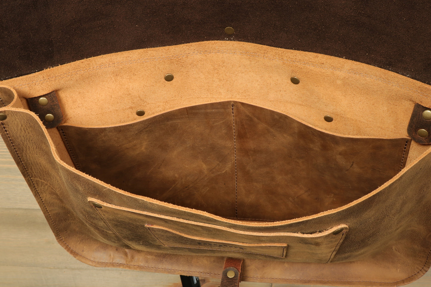 Interior view of a Taylor Guitars messenger bag featuring natural leather and multiple storage compartments