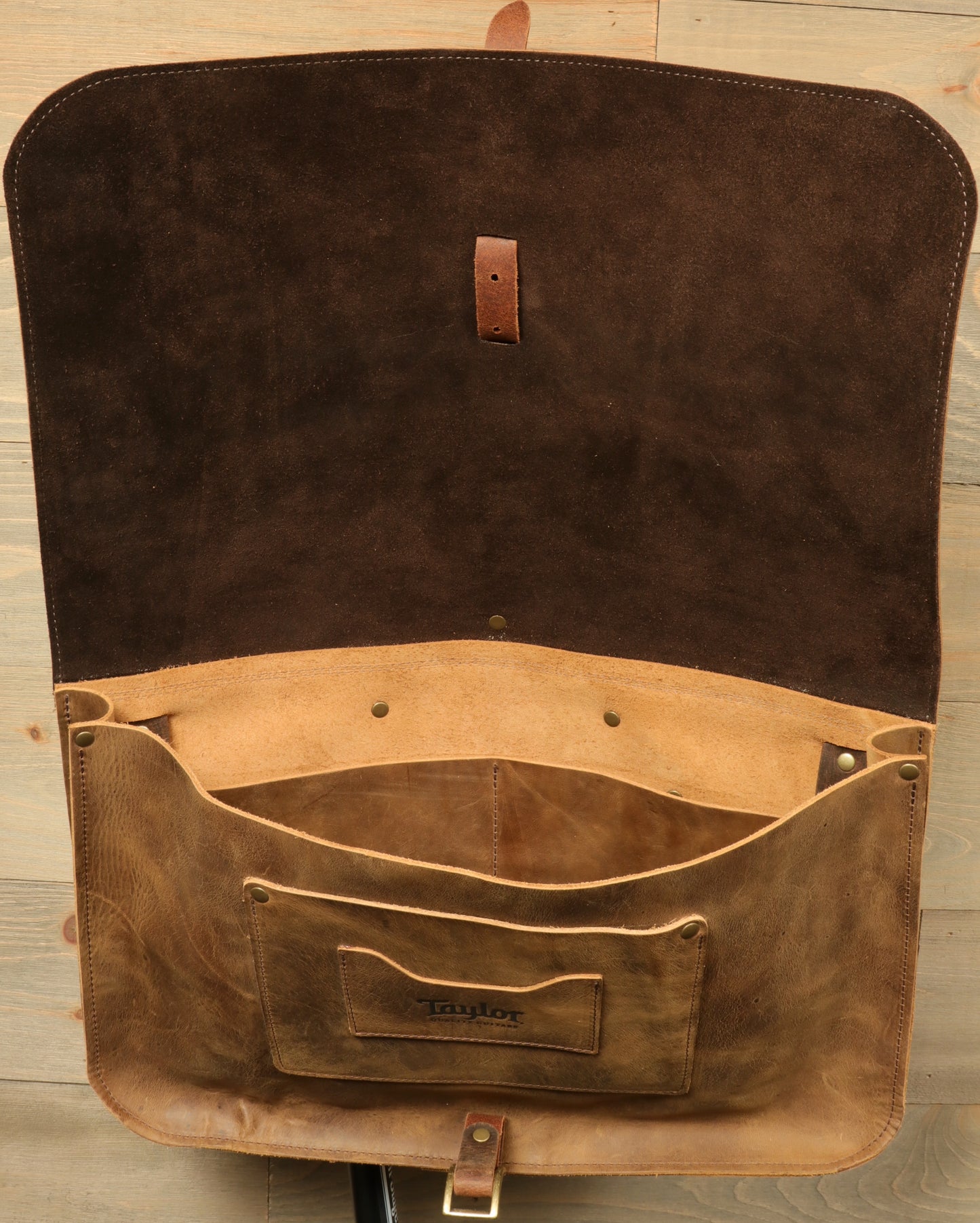 Open Taylor Guitars messenger bag featuring a spacious interior and soft suede lining for musicians